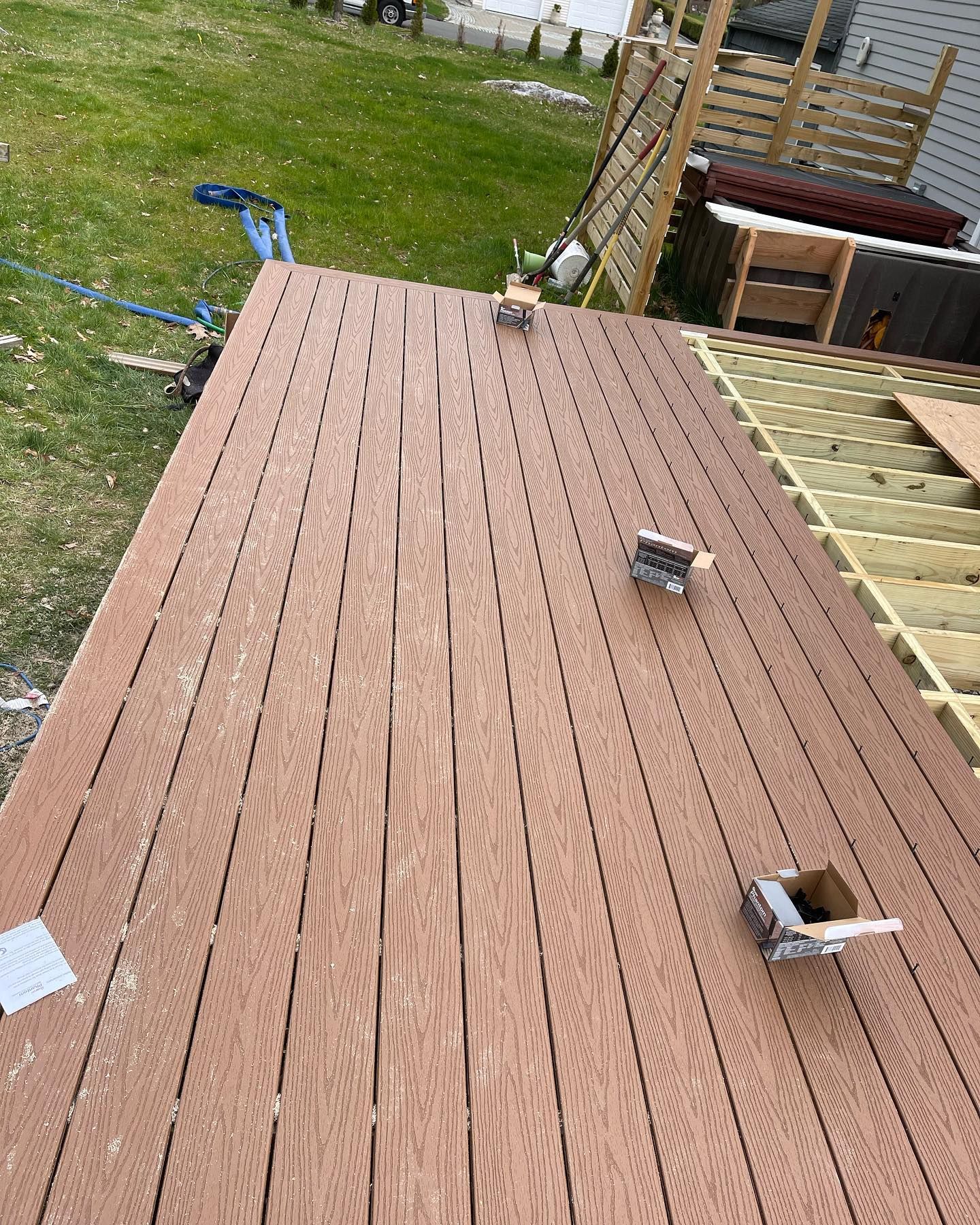 A wooden deck is being built in a backyard.