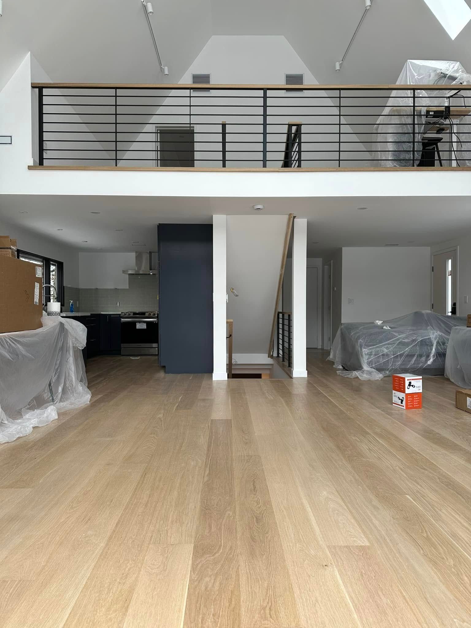 A large room with hardwood floors and a balcony.