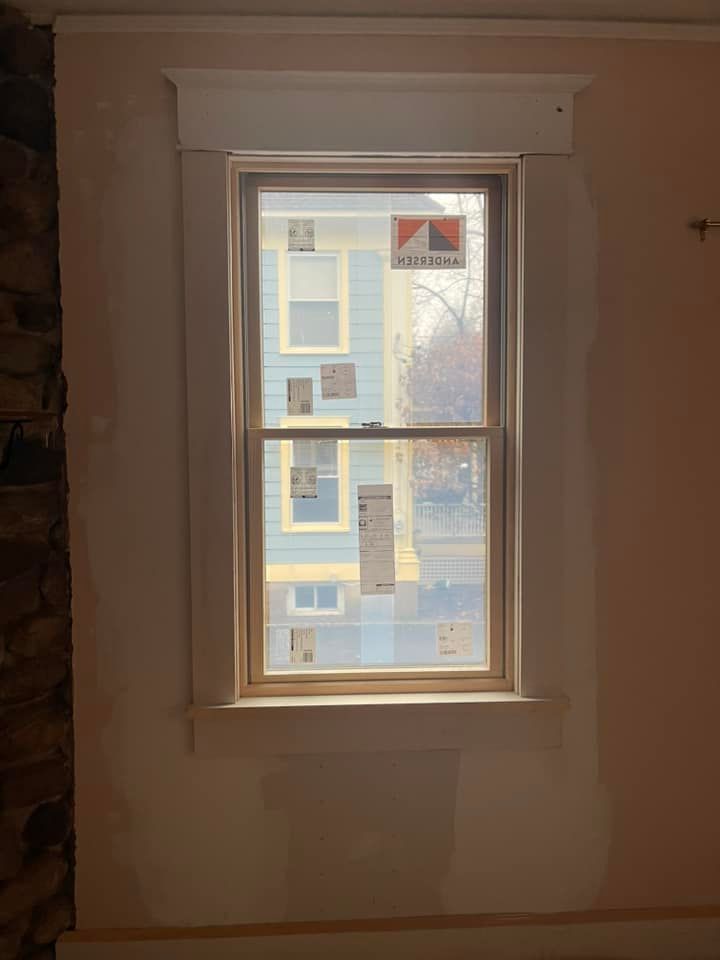 A window in a room with a blue house in the background.