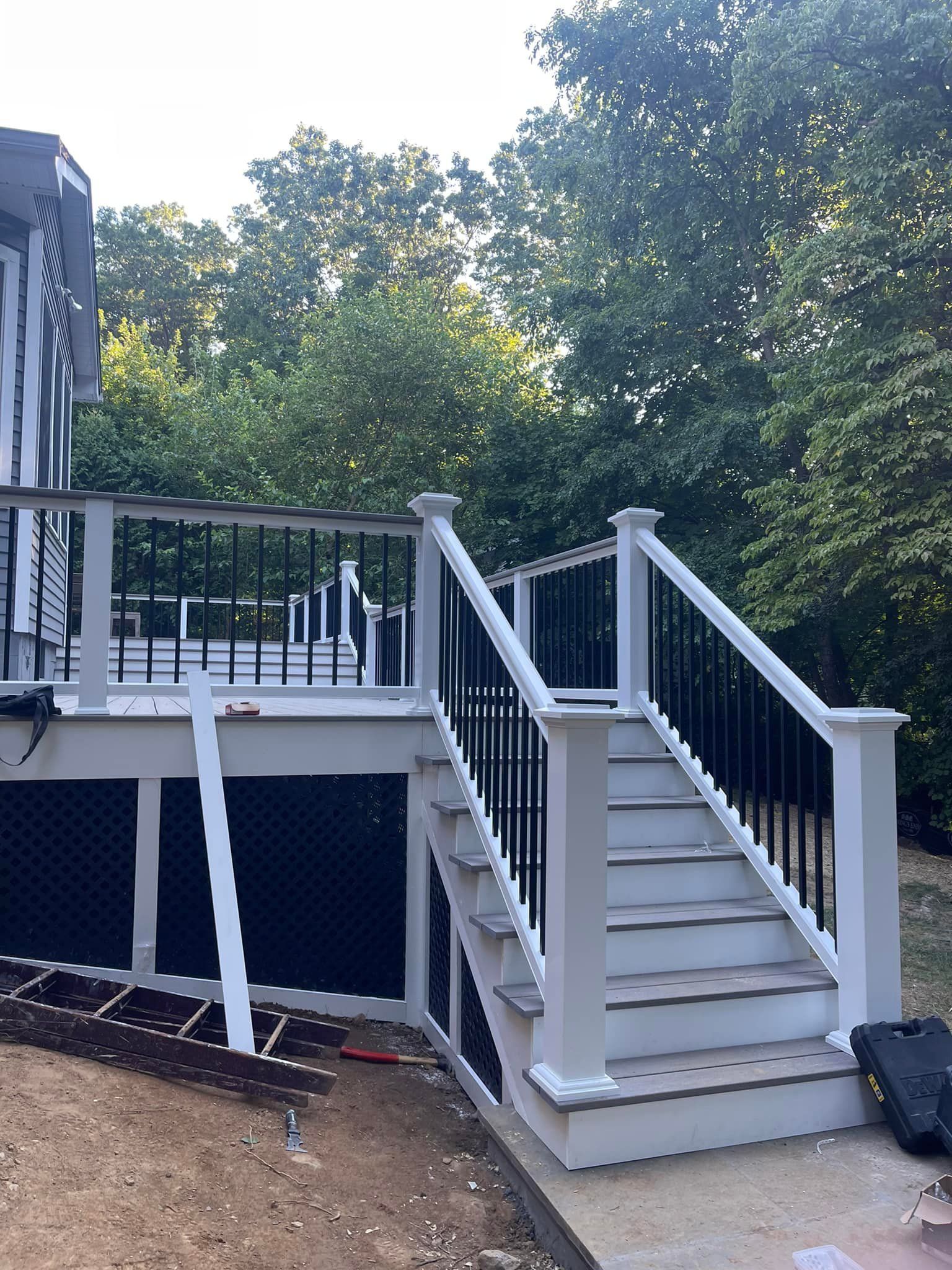 A white deck with black railing and stairs