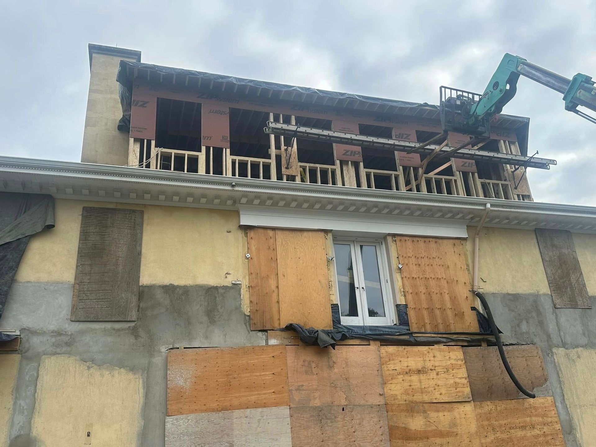 A building under construction with a crane on top of it.