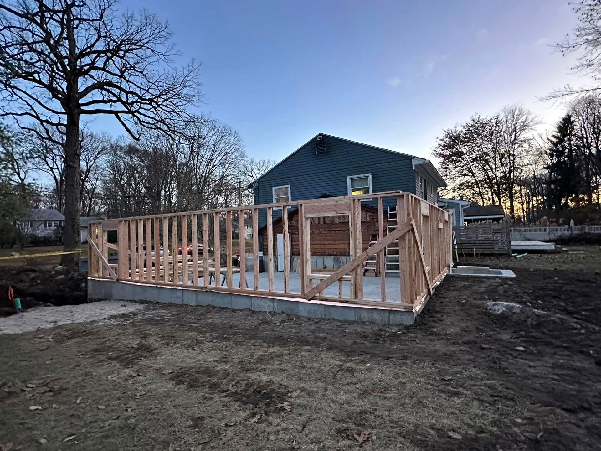 A house is being built in a backyard with a wooden frame.