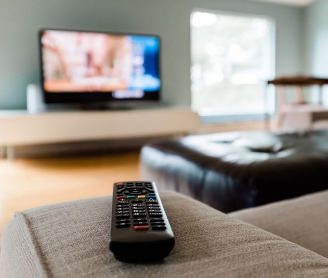 Close-Up of a Remote Control Sitting on a Couch in an Empty Modern Living Room | Mildura, Vic | a & R Electronics