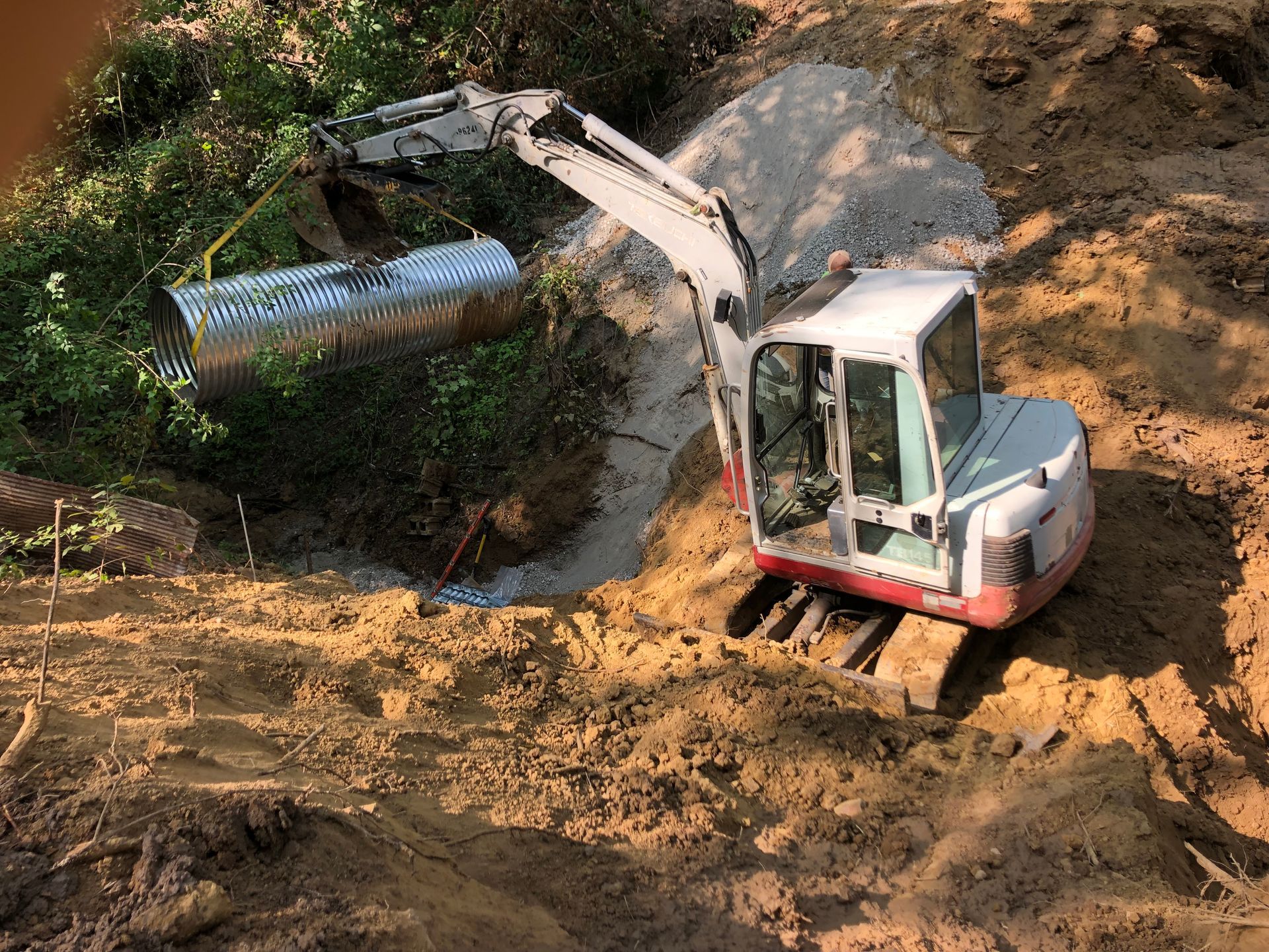 A small excavator is digging a hole in the dirt.