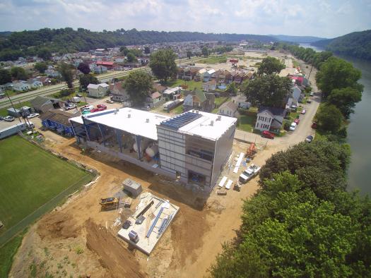An aerial view of a building under construction next to a river.