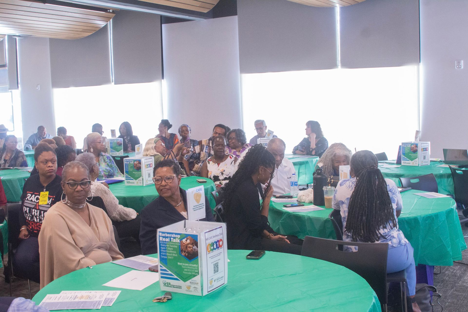 People seated at round tables in a conference room