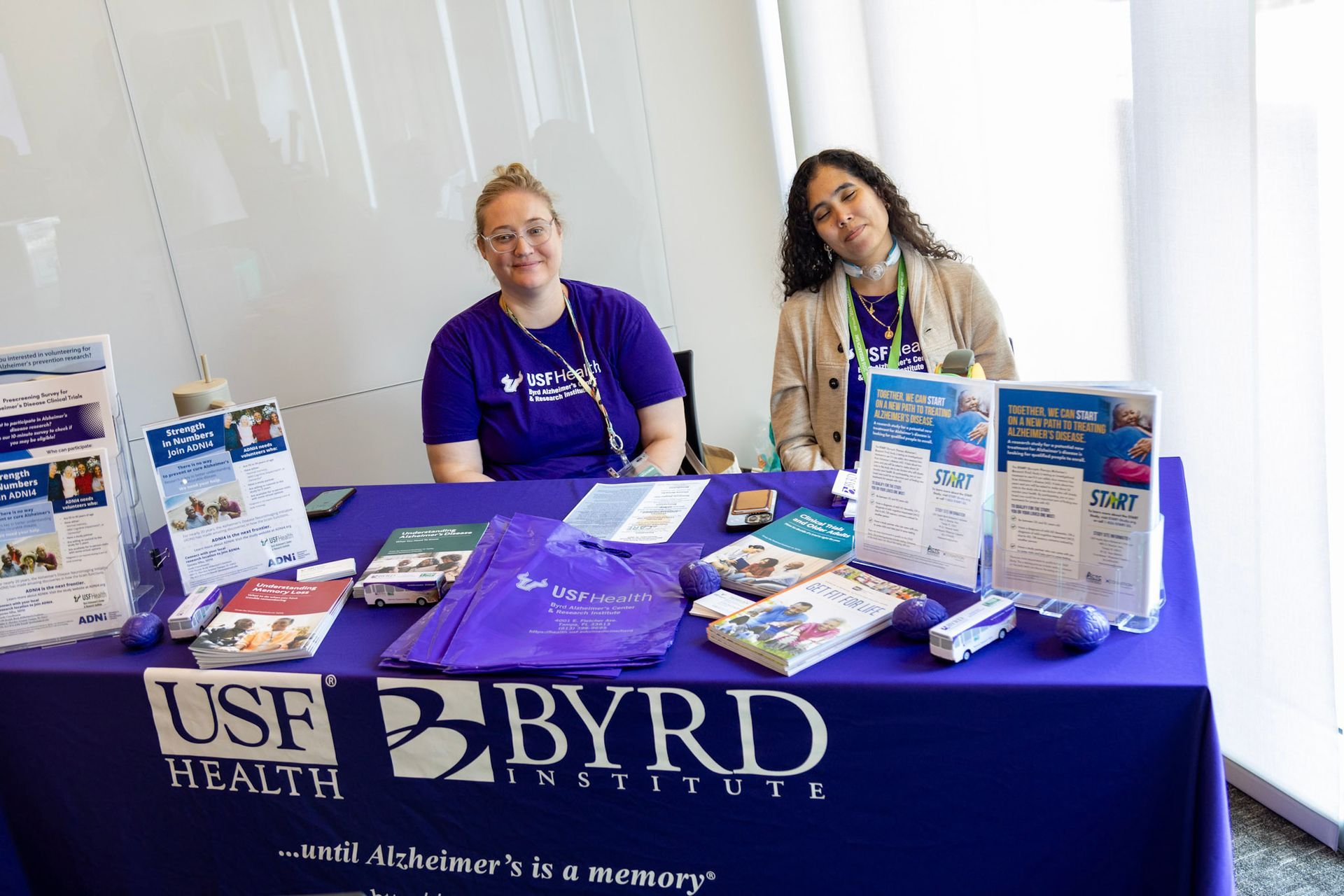 Two women at a table with promotional materials for the USF Health Byrd Alzheimer's Institute.