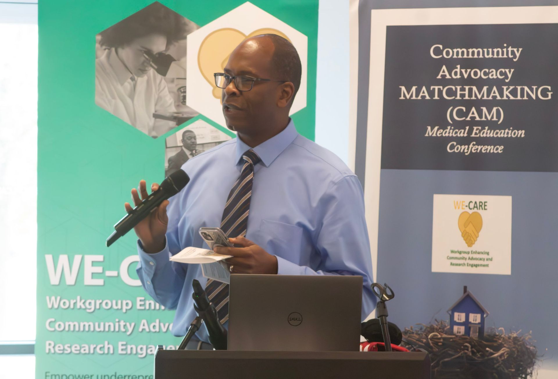 Man speaking at a conference podium with a microphone, 