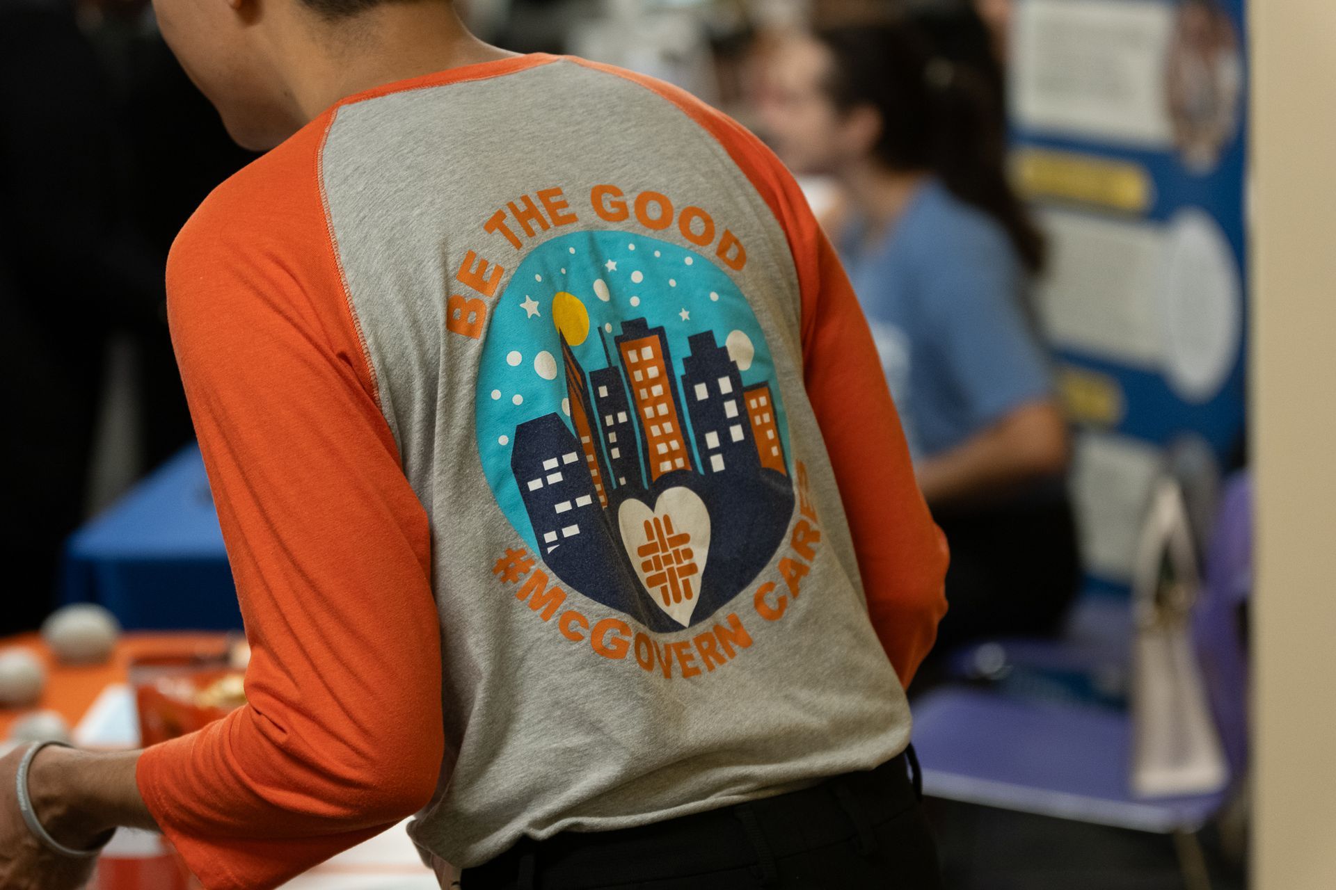 Person wearing an orange and gray shirt with 