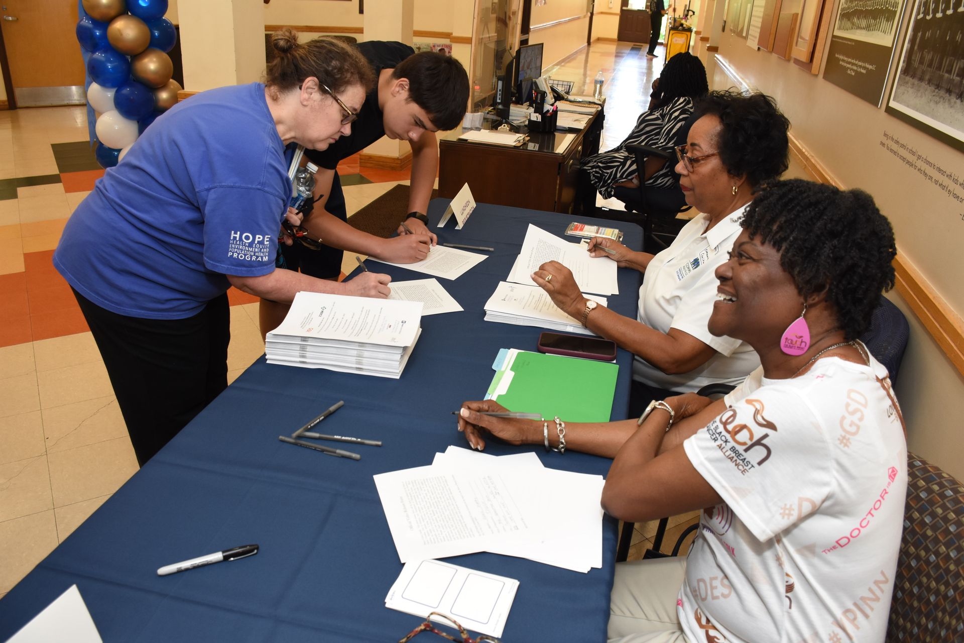 People signing documents at a table