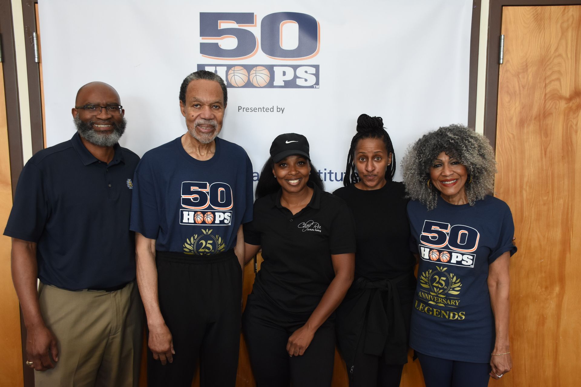 Five people standing in front of a banner that says 