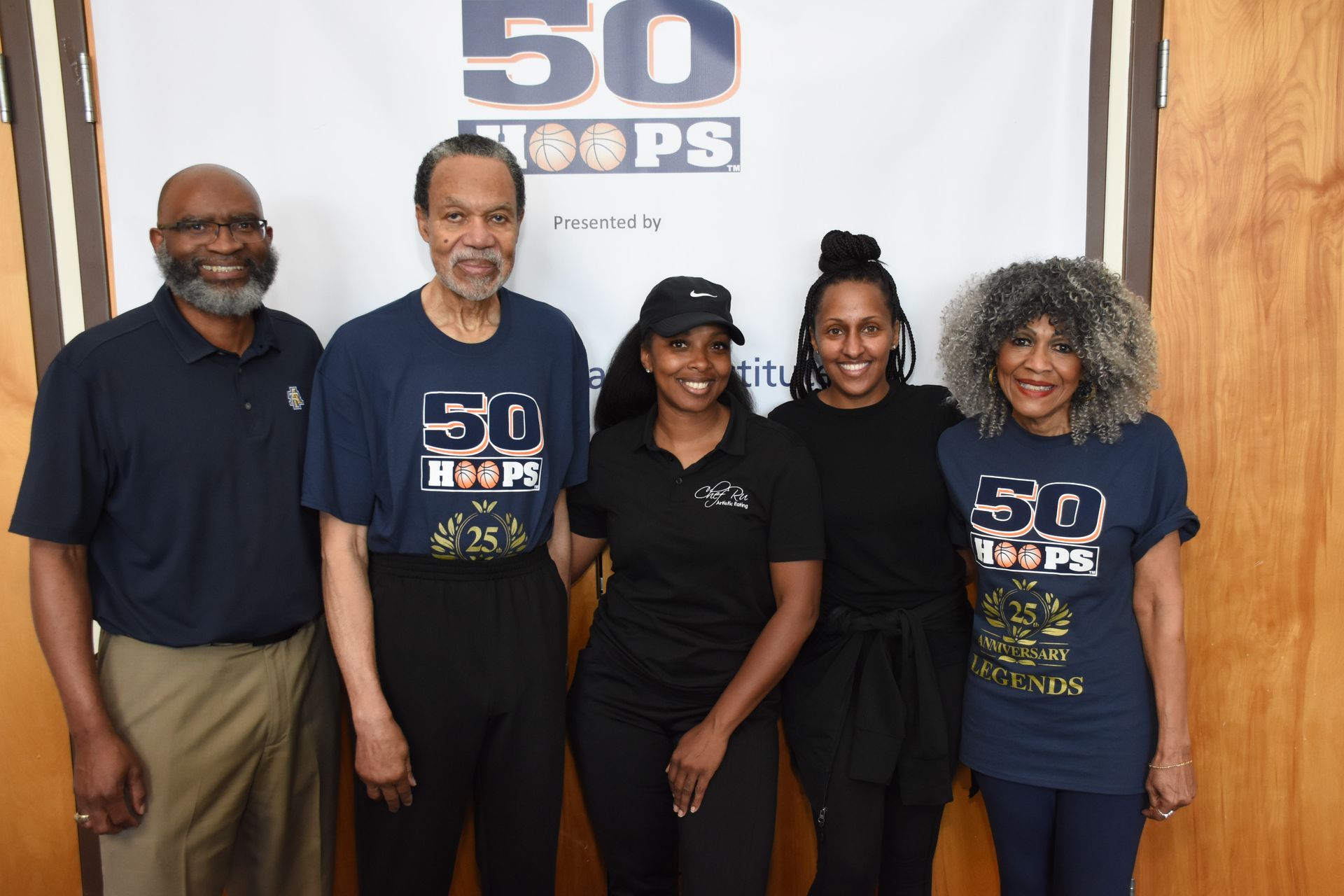 Group poses in front of a banner that reads 