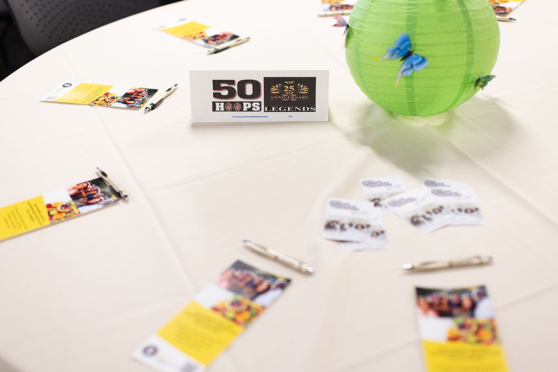 Table display with brochures, pens, a green lantern, and a sign that reads 