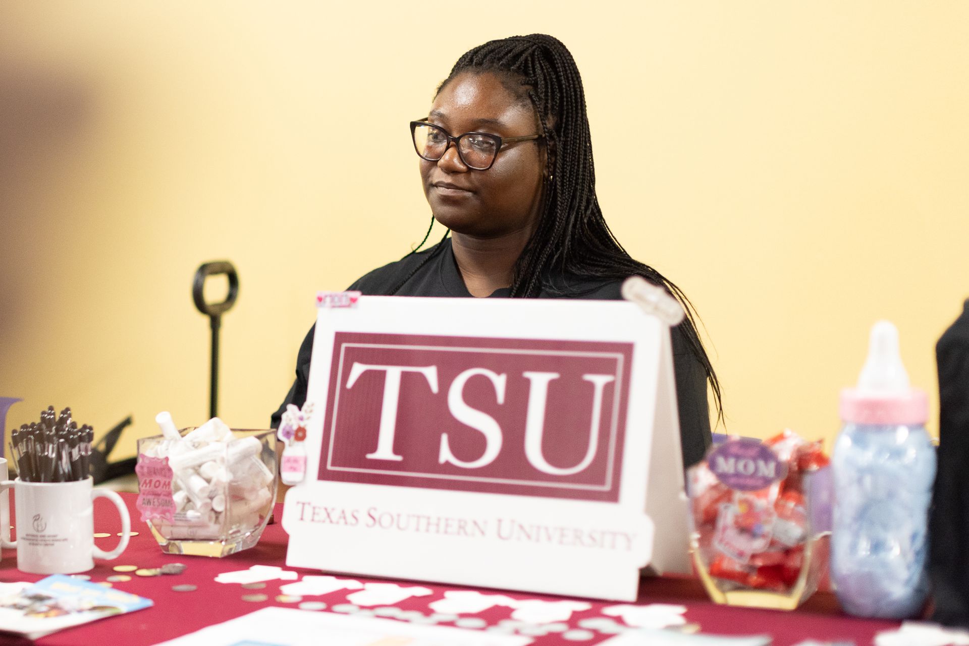 Woman at a Texas Southern University information table, wearing glasses.