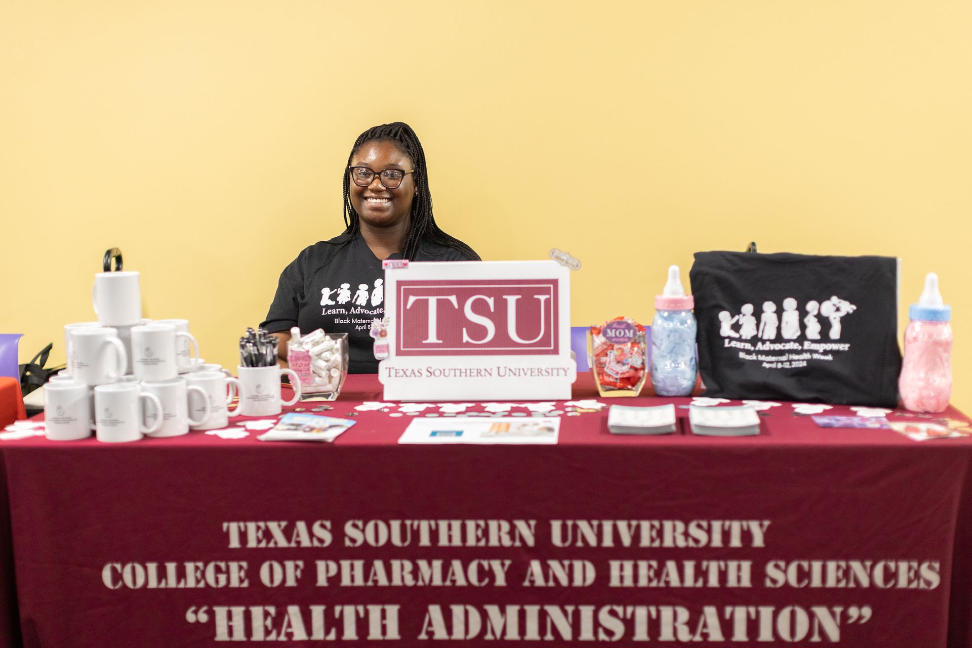 Person at a Texas Southern University information table. The table displays TSU logos and promotional items.