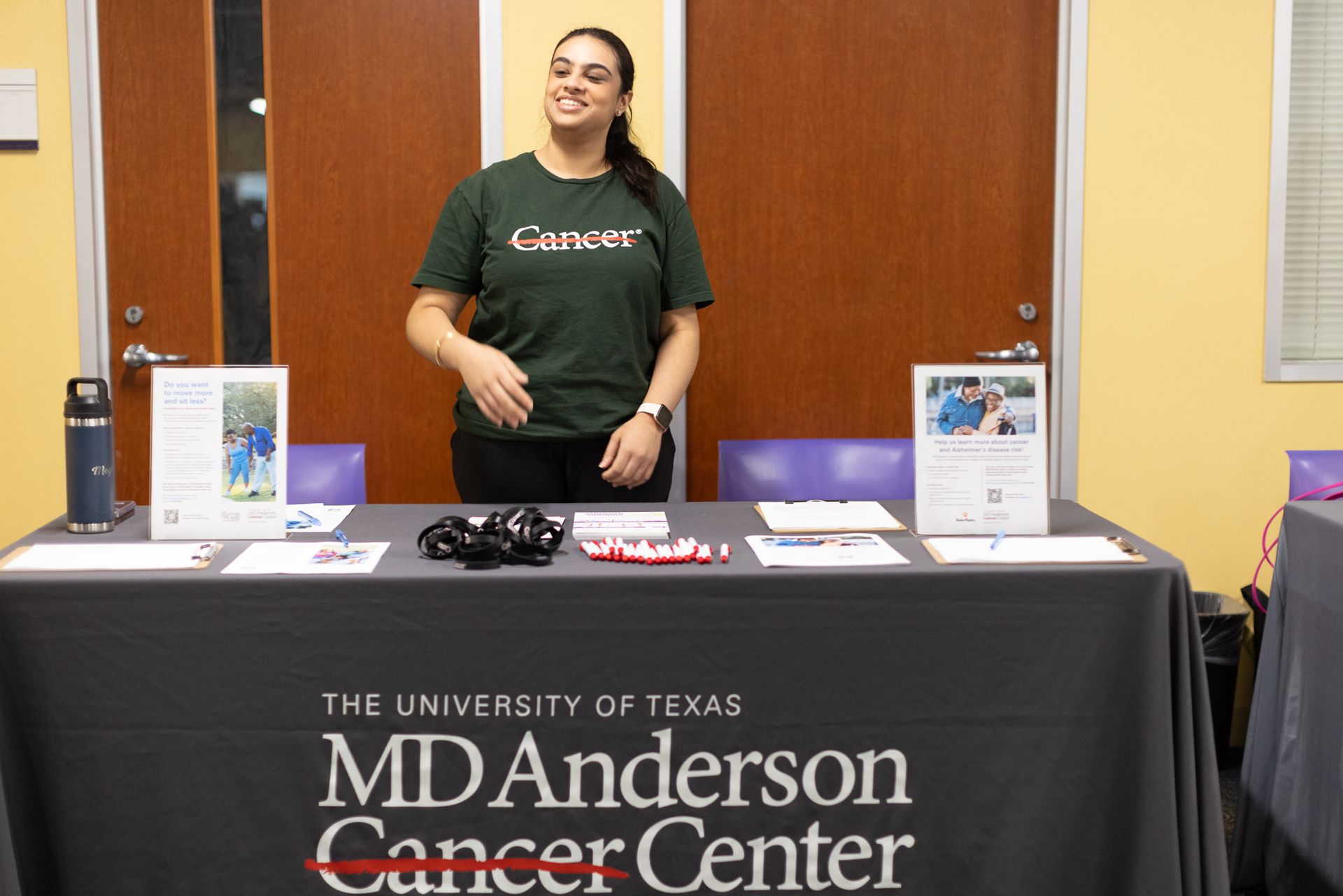 Woman at MD Anderson Cancer Center table, smiling, wearing green 