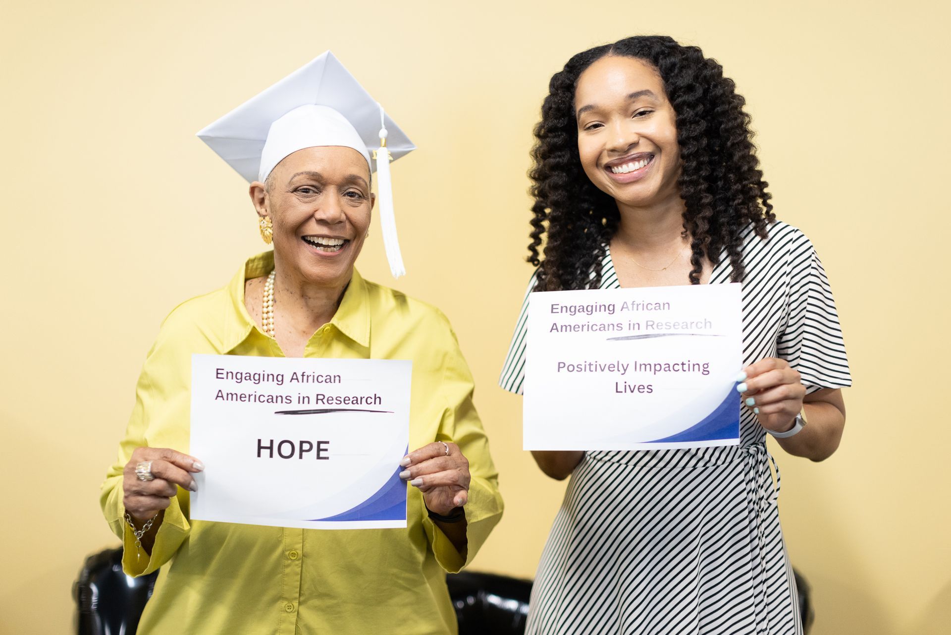 Two smiling women hold signs: 