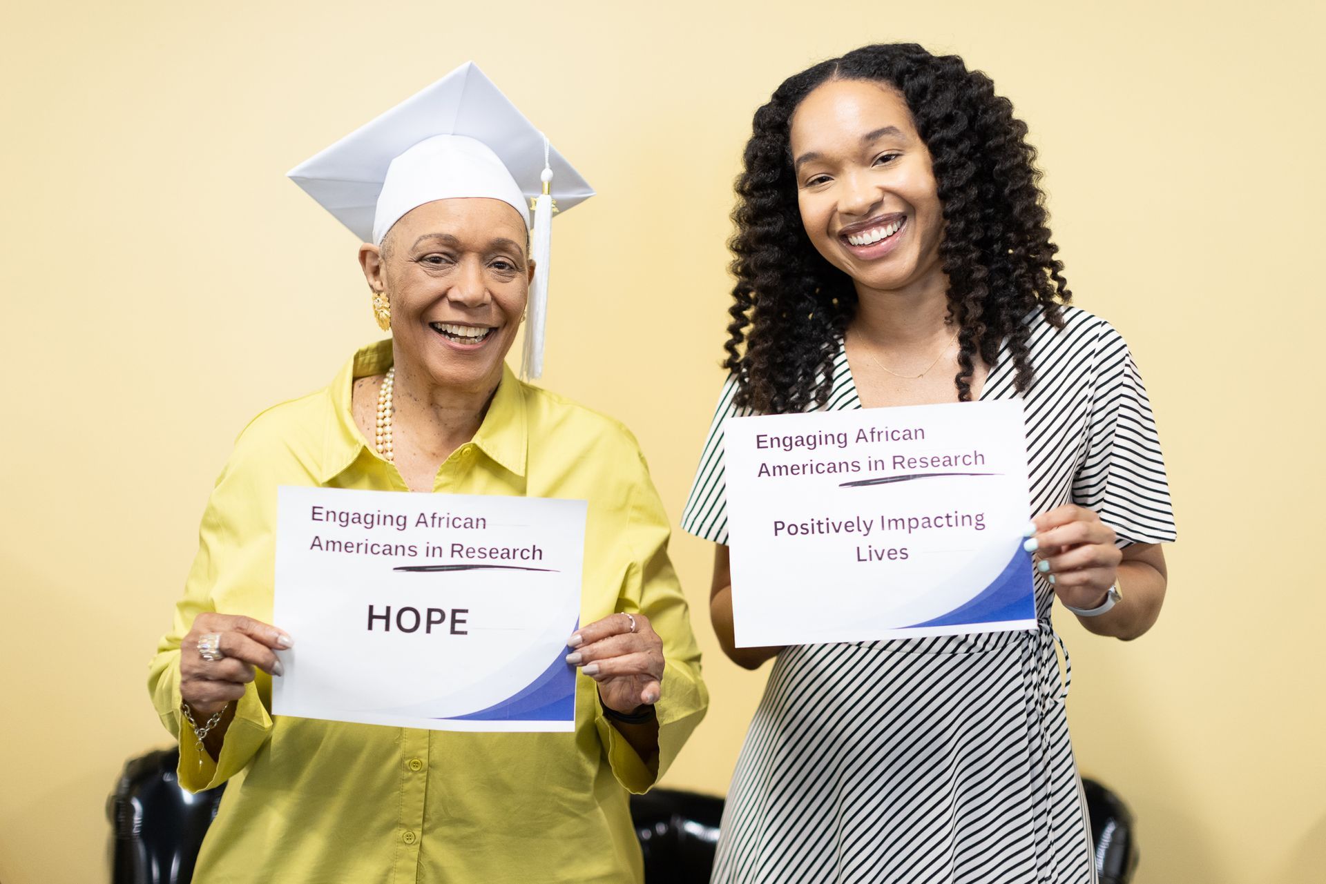 Two smiling women holding signs: 