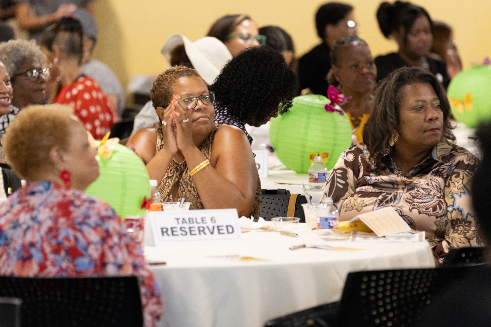People seated at tables at an event; a 