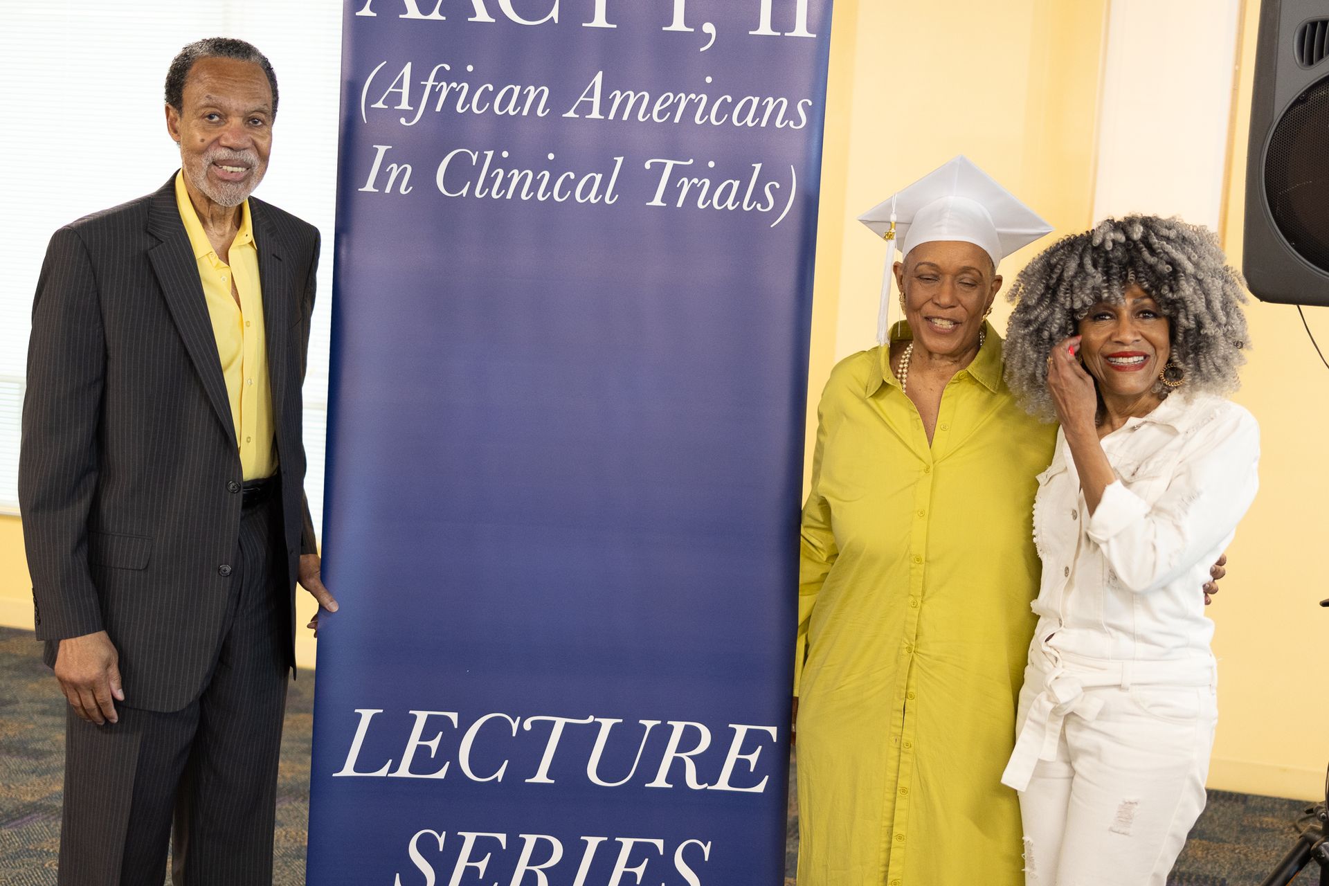 Three people pose by a 