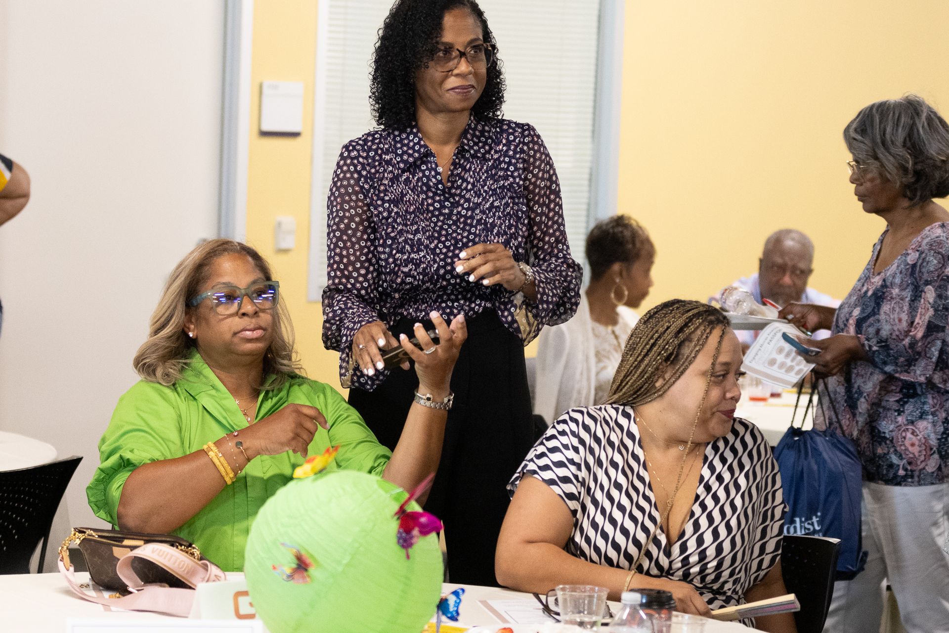 Several people gathered at a table, some smiling and talking. 