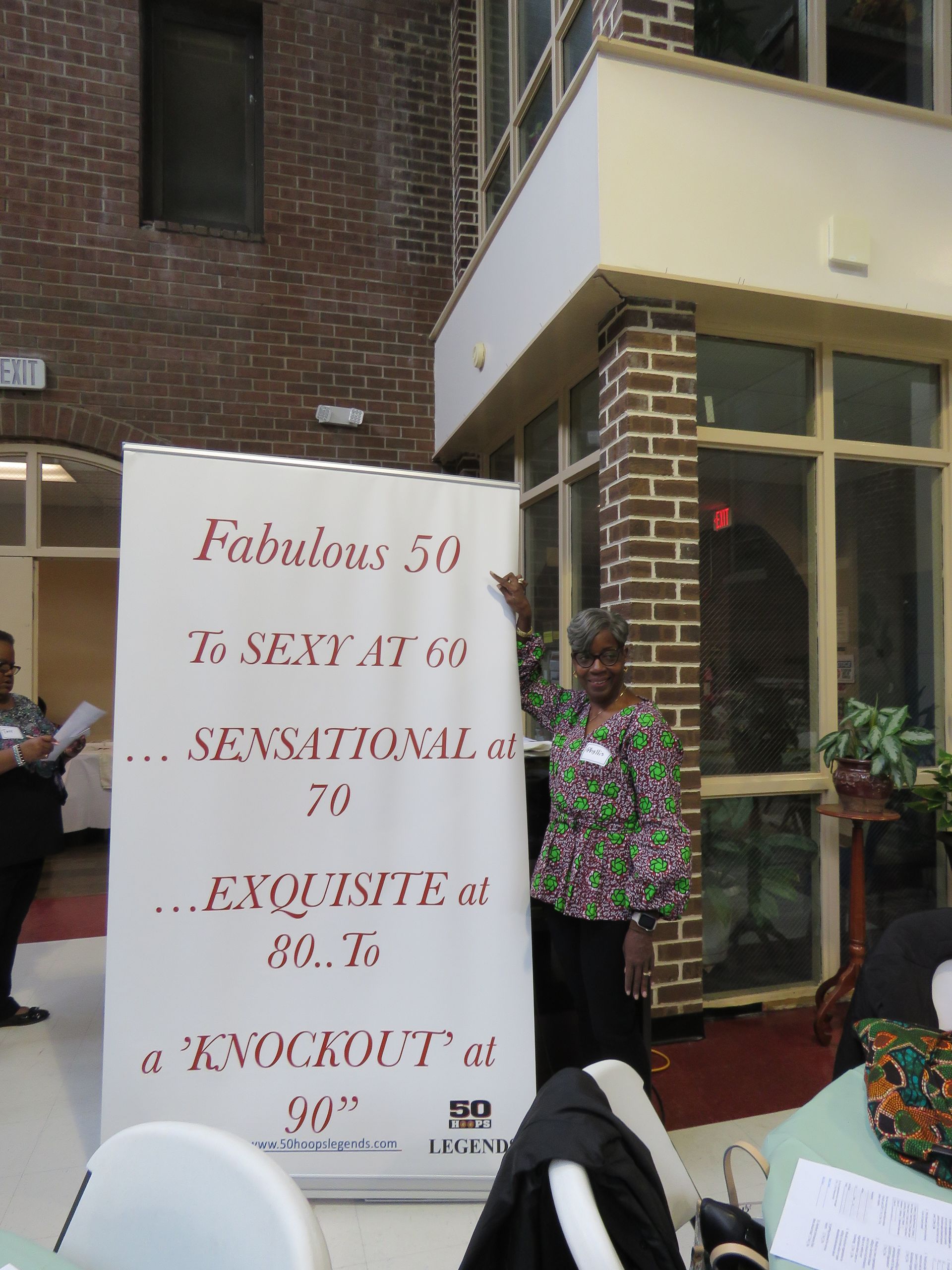 Woman stands next to a banner