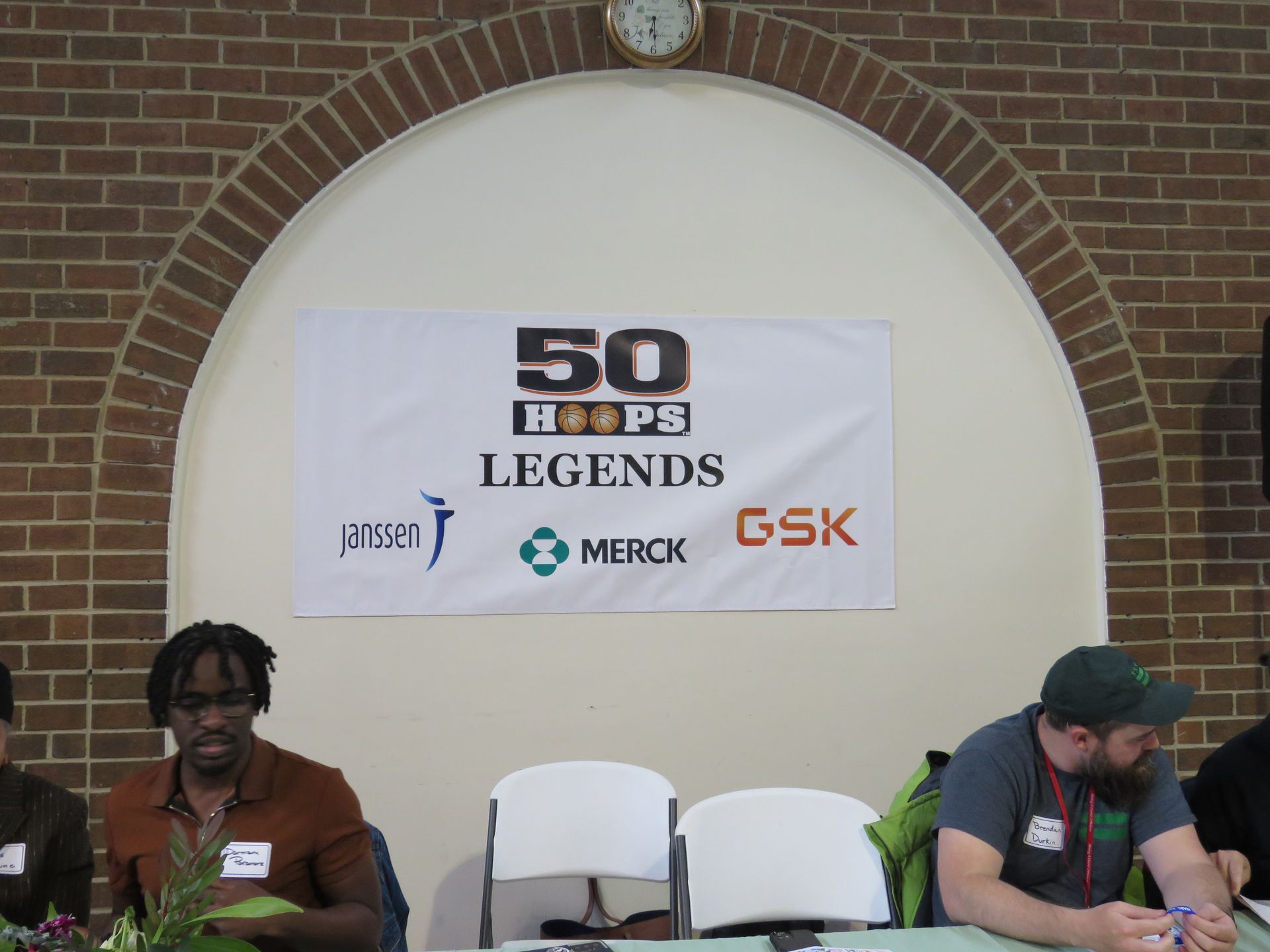 People at a table under a banner that says 