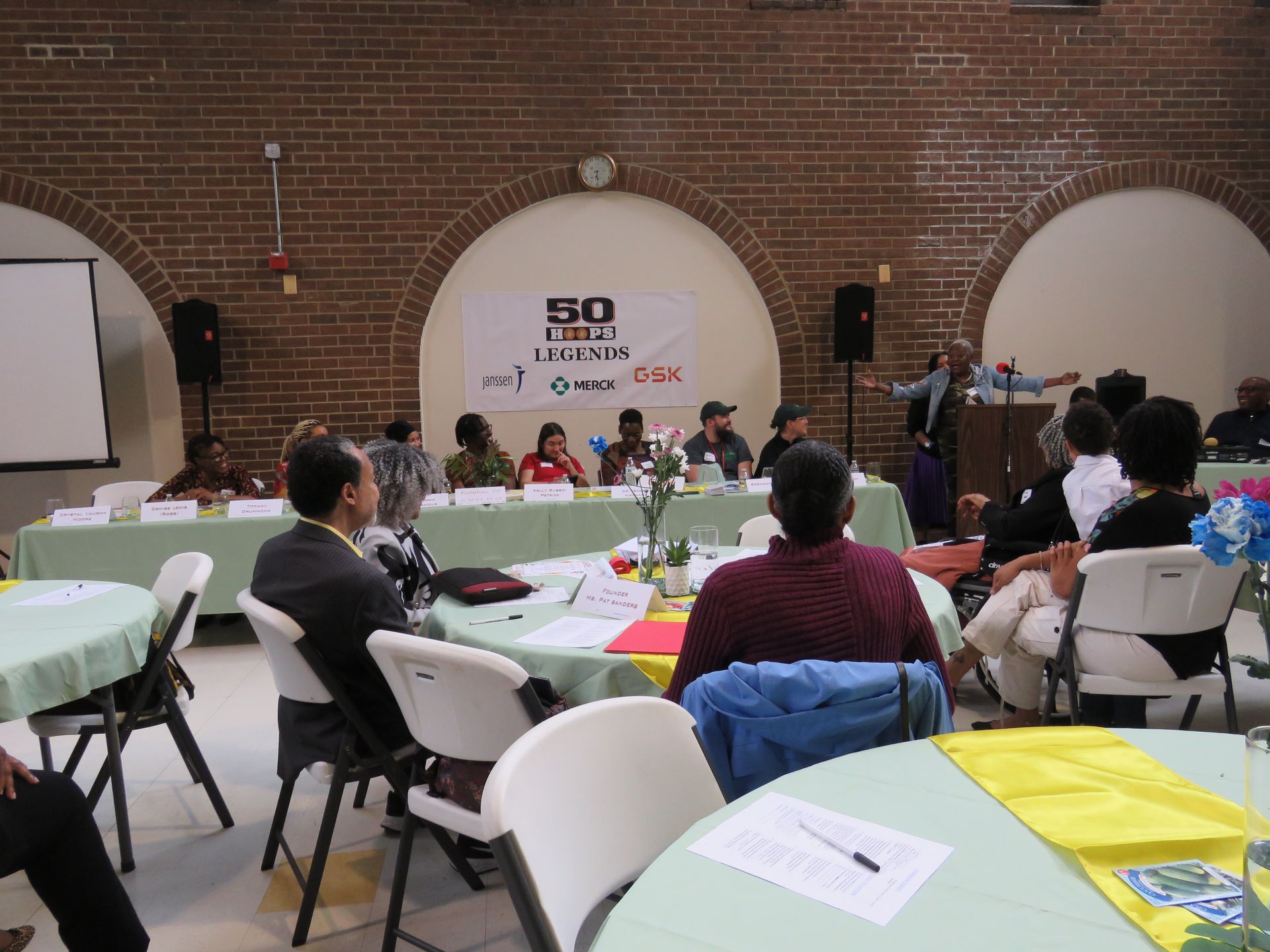 Panel discussion in a brick-walled room. 