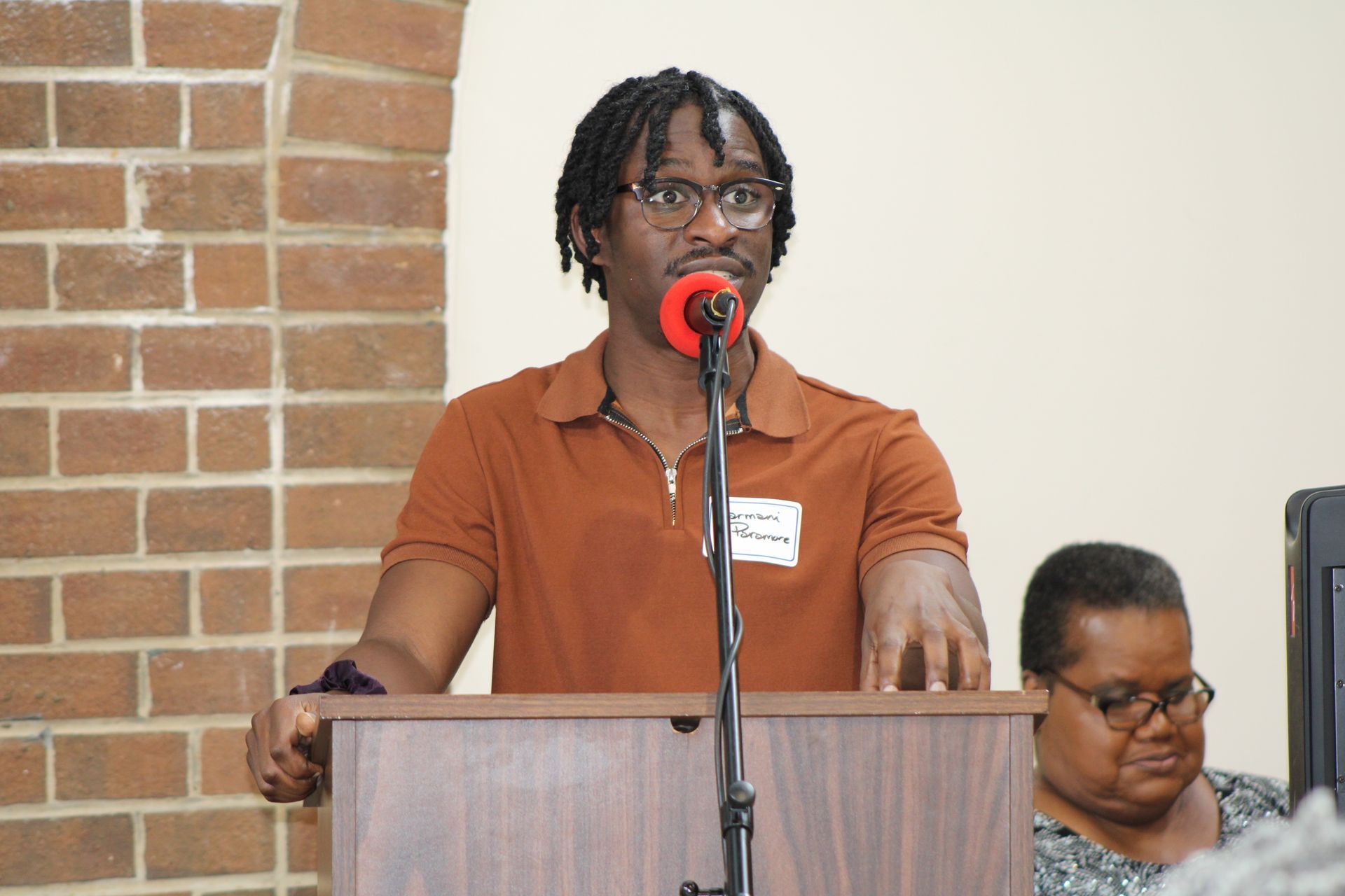 Man speaking at a podium with a microphone. 