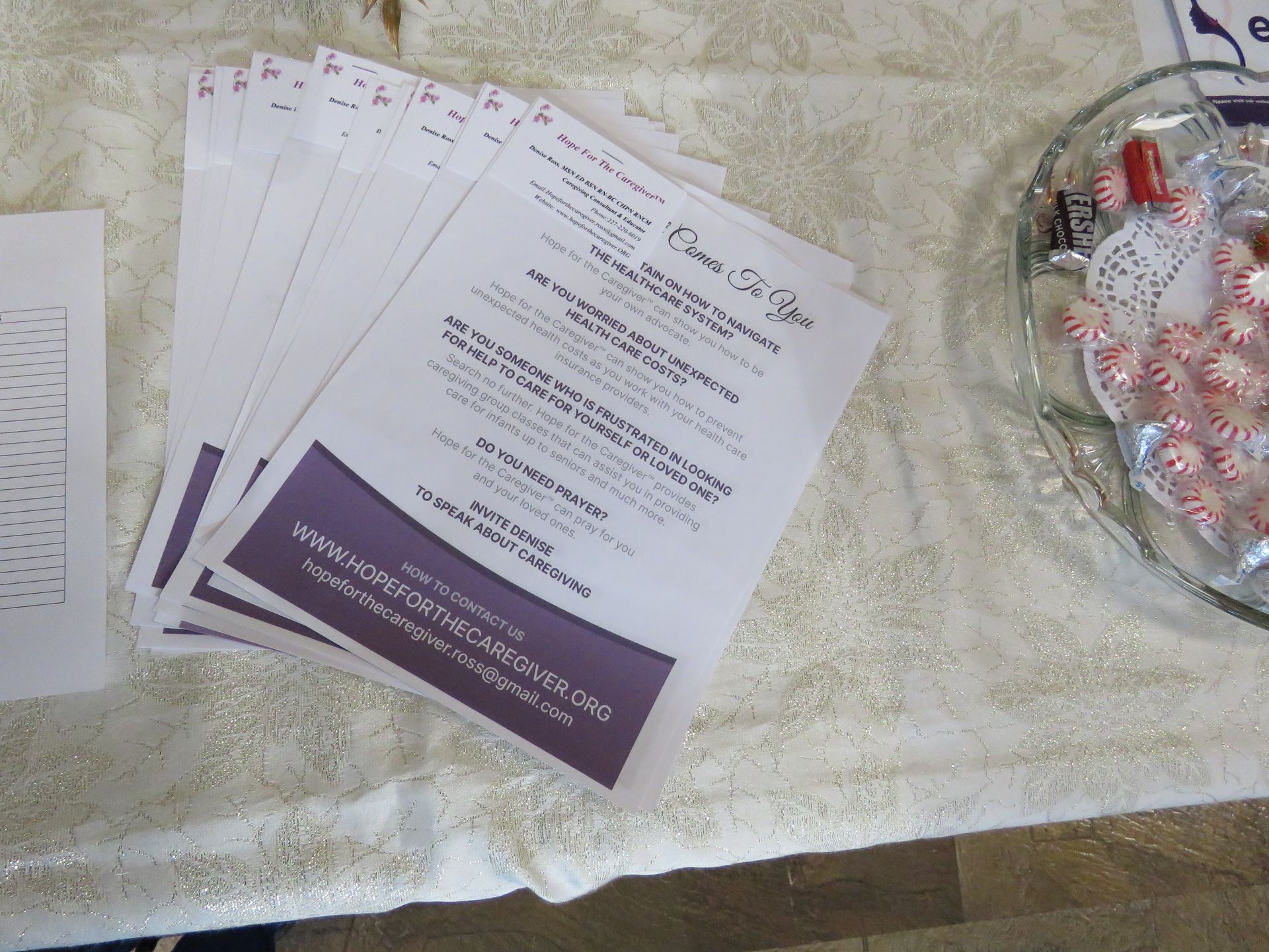 Stack of flyers on a table next to a dish of peppermints.