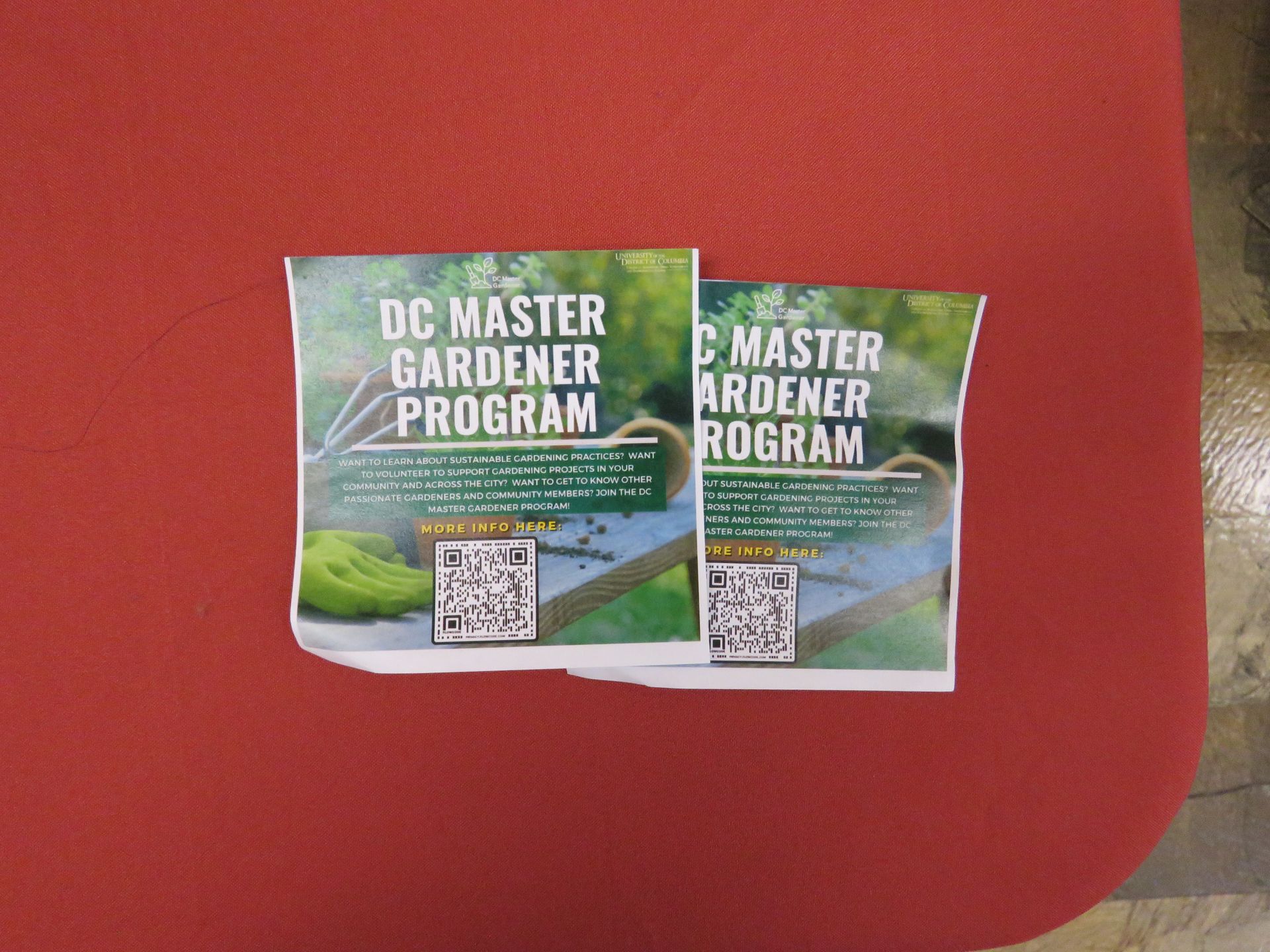 Two flyers: DC Master Gardener Program, on red surface. QR codes and text visible.