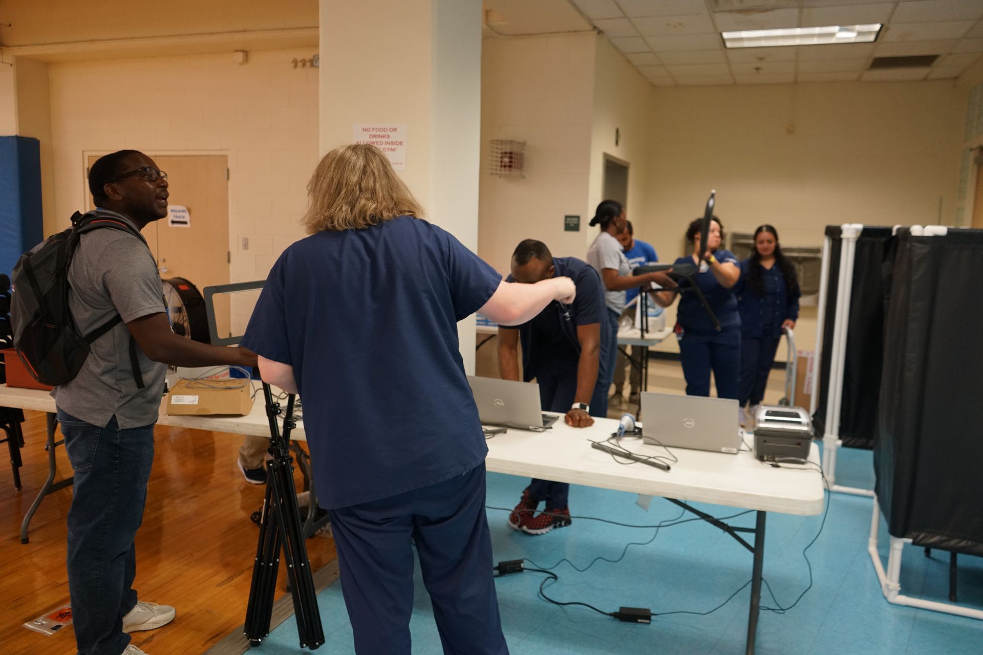 People at a vaccination clinic, setting up and receiving vaccinations.