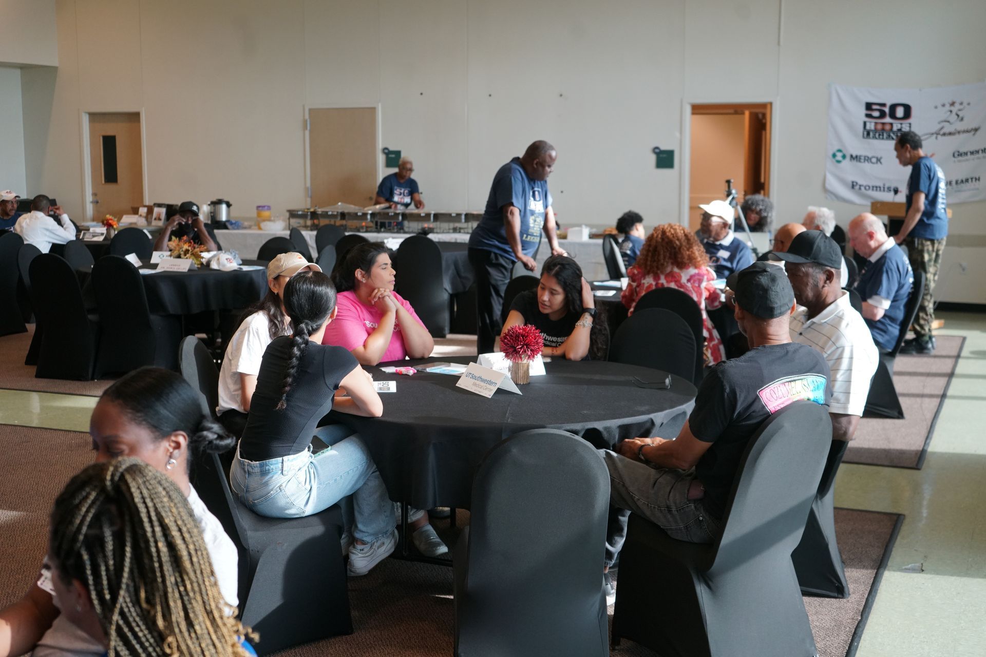 People seated at round tables in a large room, likely at a meeting or event.
