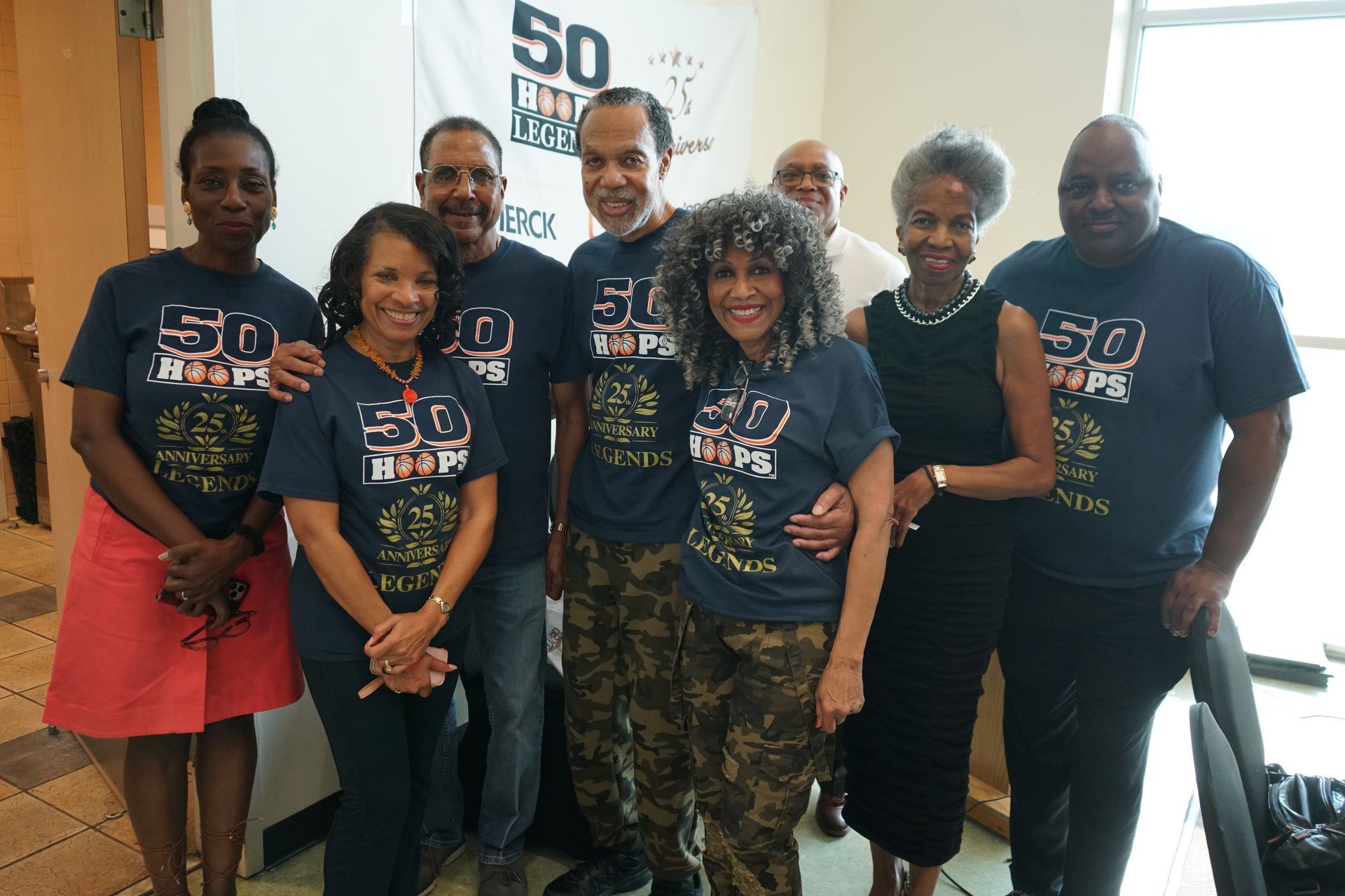 Group of people wearing matching shirts posing for a photo.