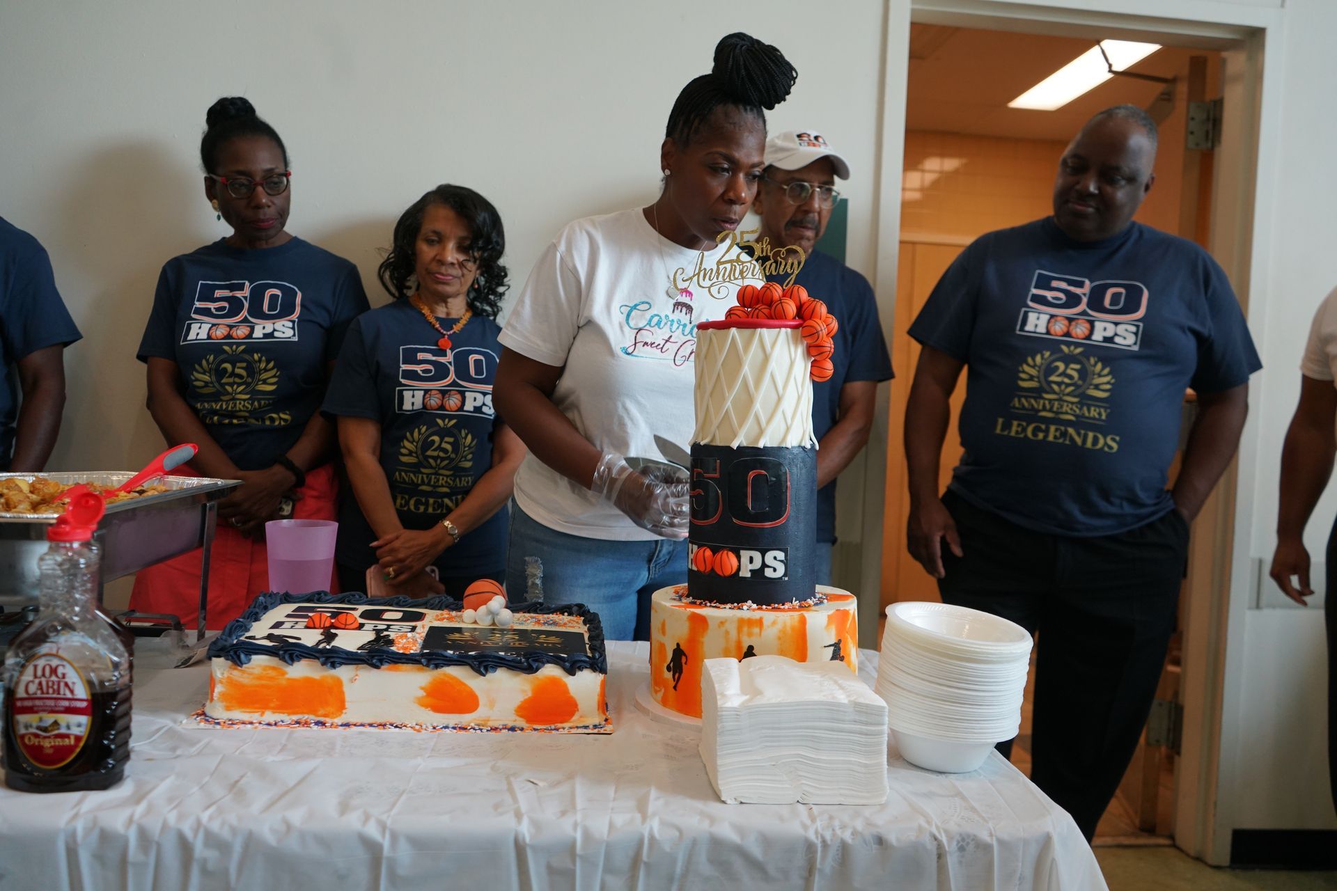 People at a birthday celebration with decorated cakes and t-shirts that say 