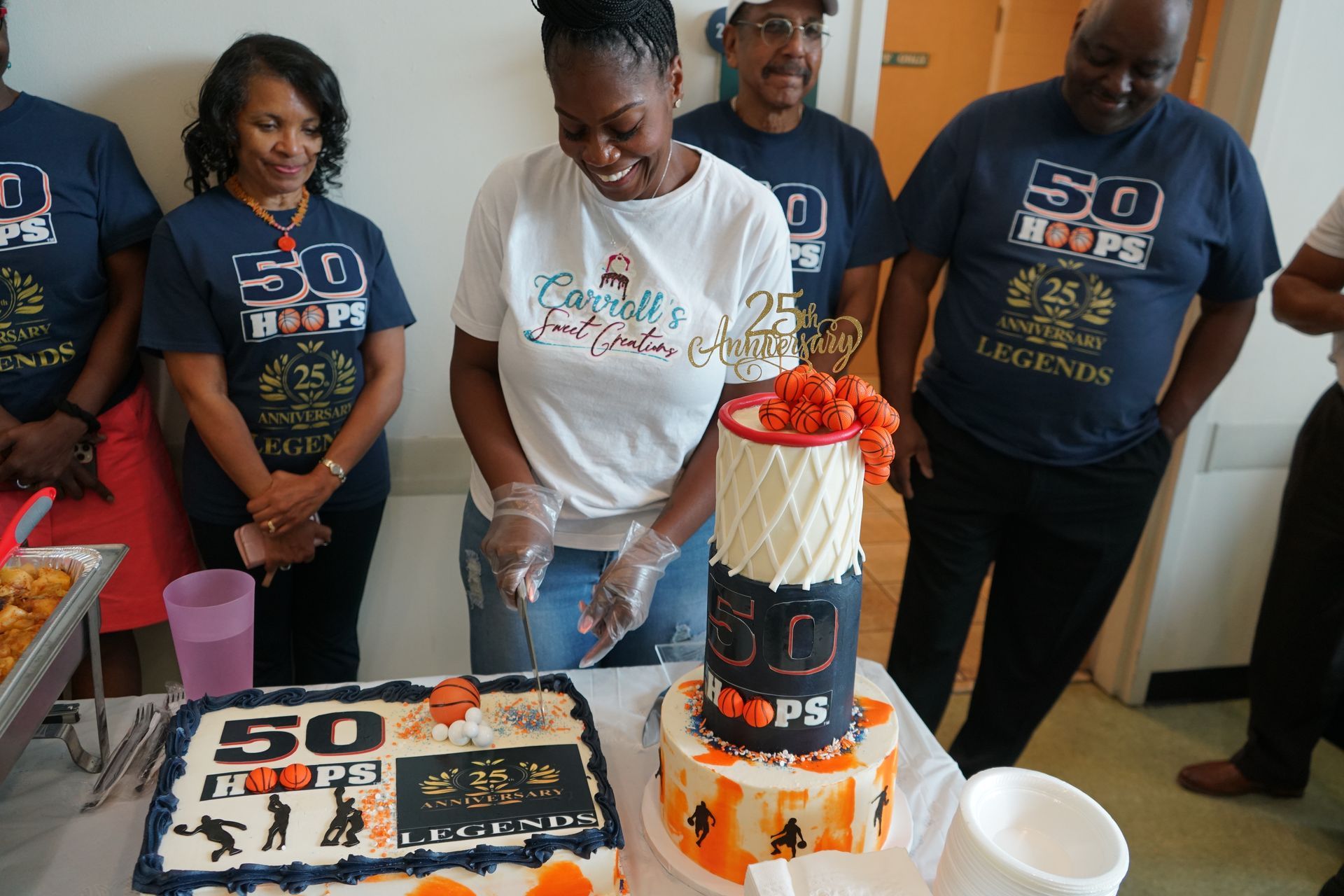Woman cutting a basketball-themed birthday cake, with guests wearing 