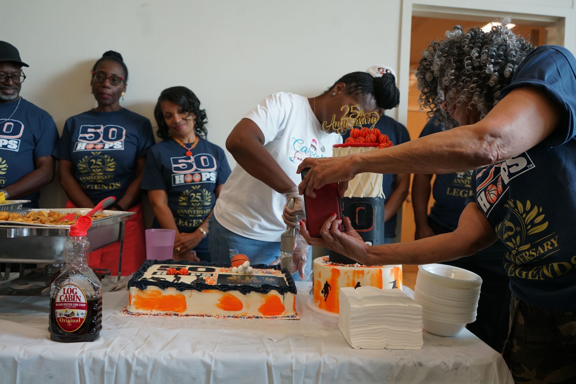 People cutting cake at an event with 