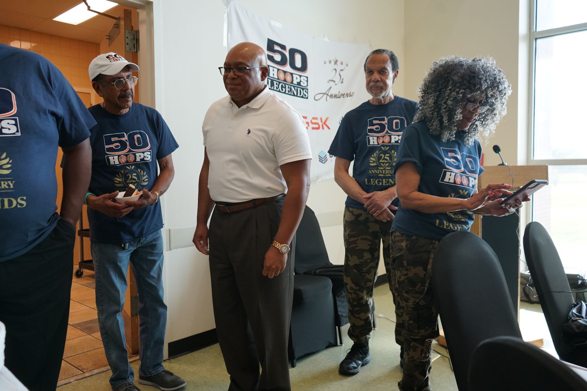 People in a room with a banner that says 