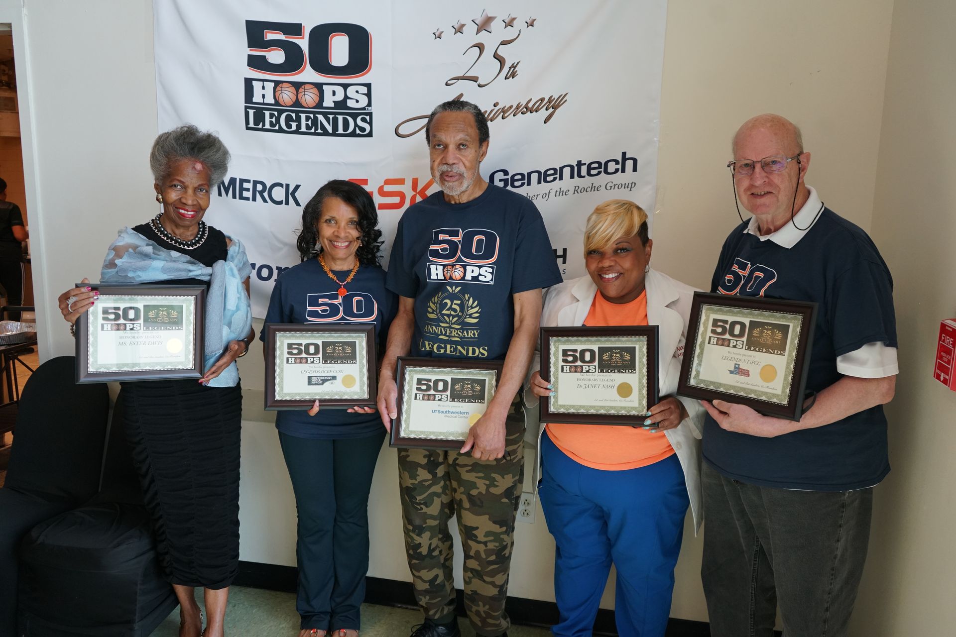 Five people holding framed certificates, standing in front of a banner that reads 
