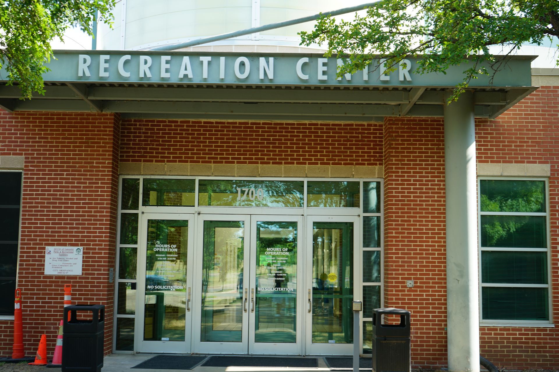 Entrance to a brick Recreation Center with glass doors and a sign above.
