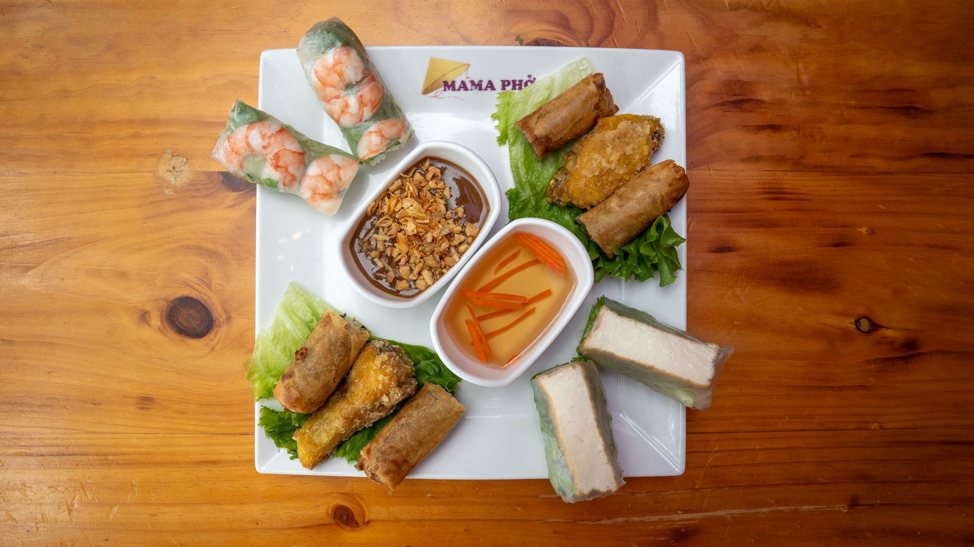 A white plate topped with a variety of food on a wooden table.