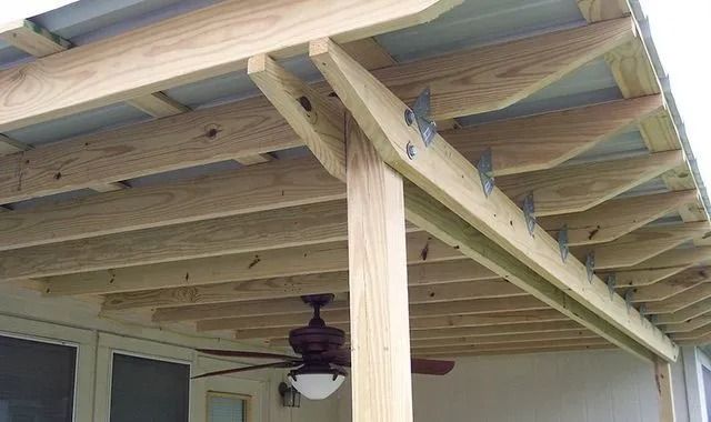A wooden porch with a ceiling fan and a light