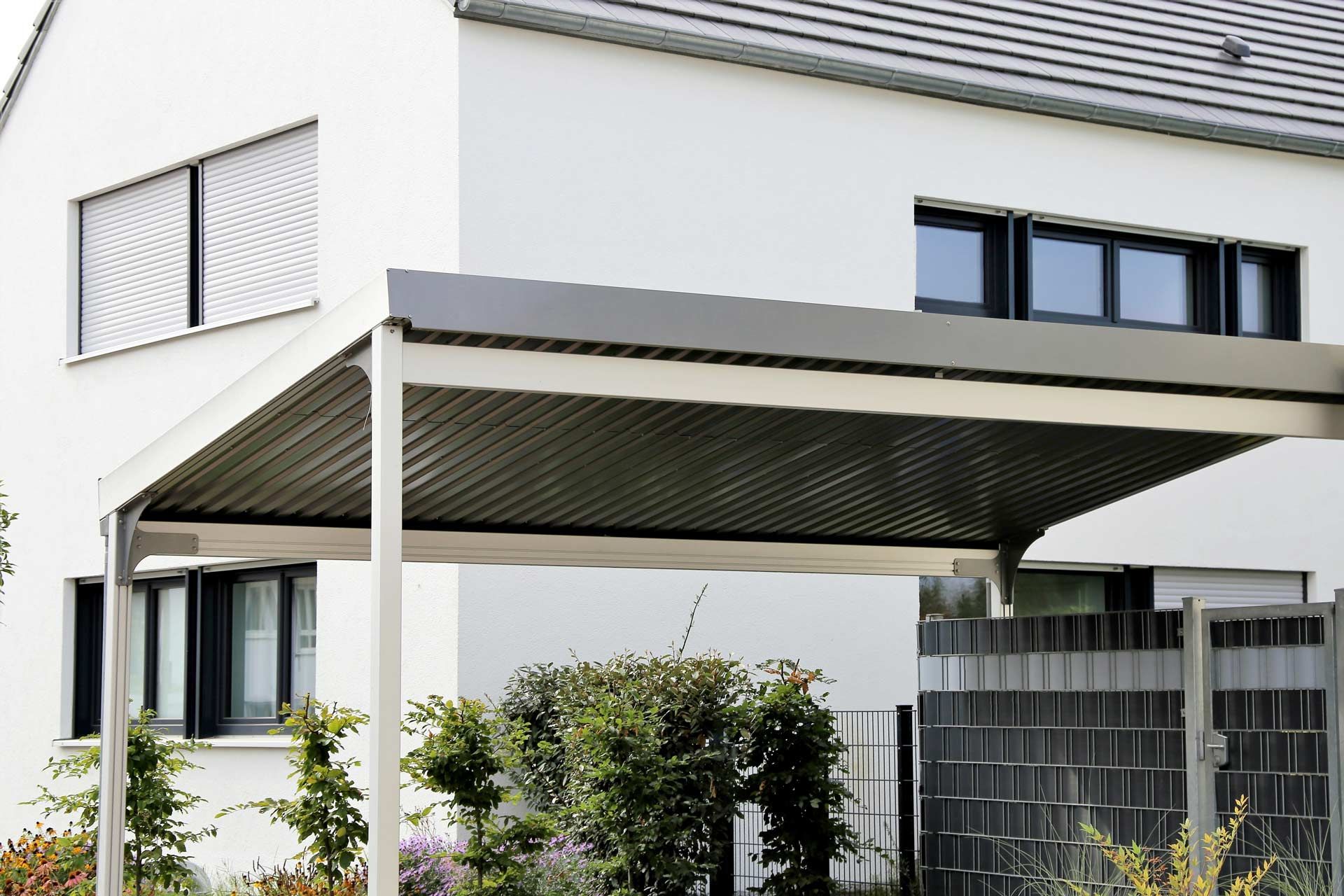 A white house with a carport in front of it