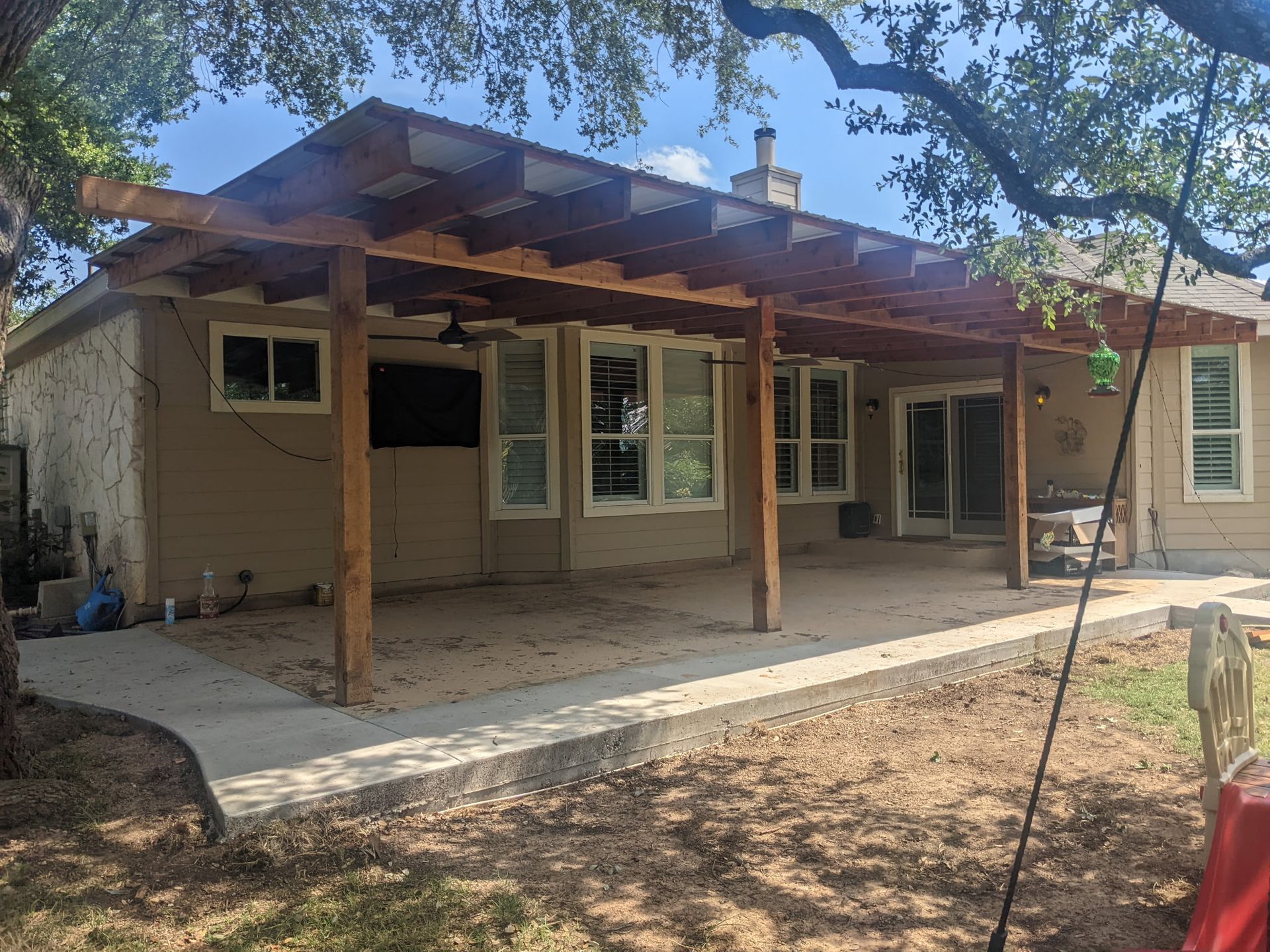 A house with a pergola on the back of it.
