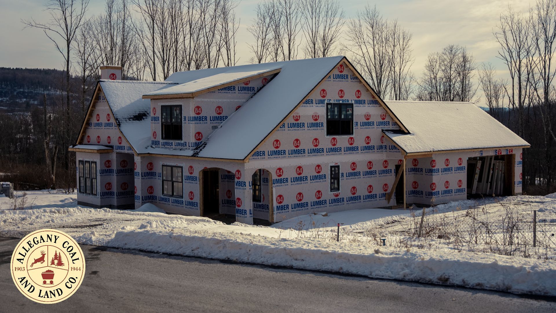 A house is being built in the snow with a sign that says farm