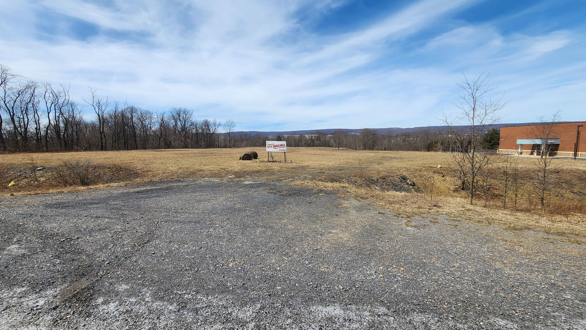 A vacant lot with dry grass and a 