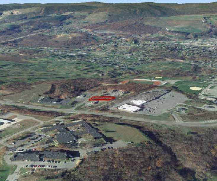 An aerial view of a hilly landscape with commercial buildings and a golf course.