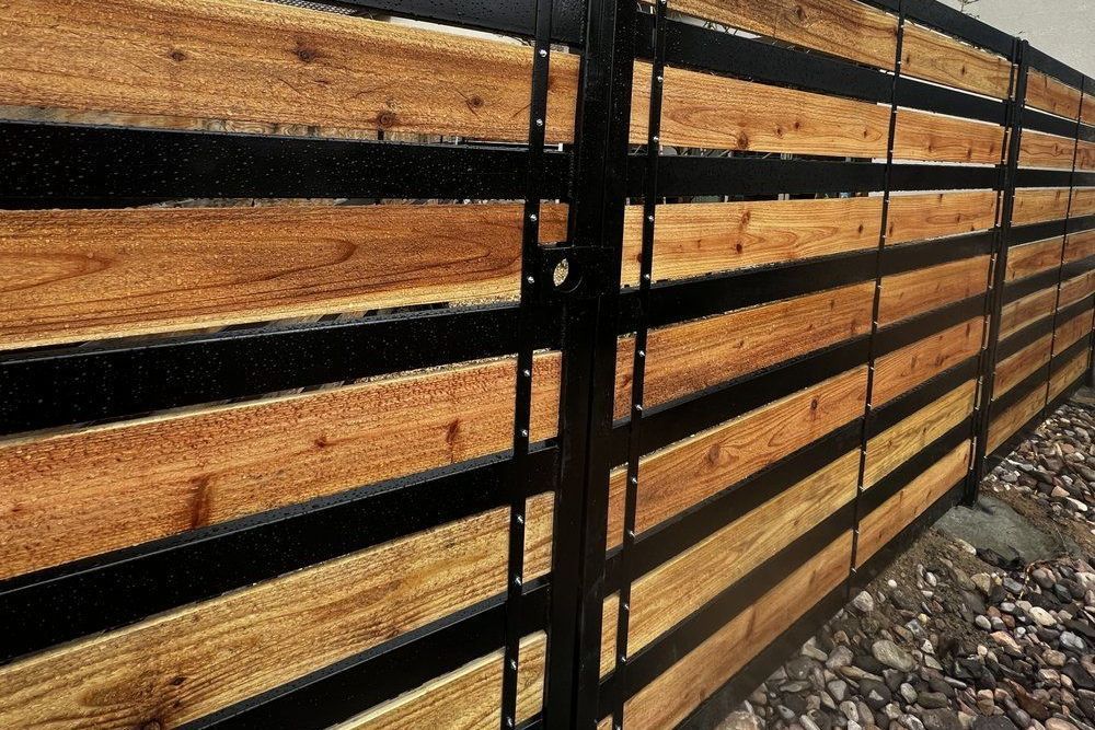 A brown wood and metal fence along a rocky path