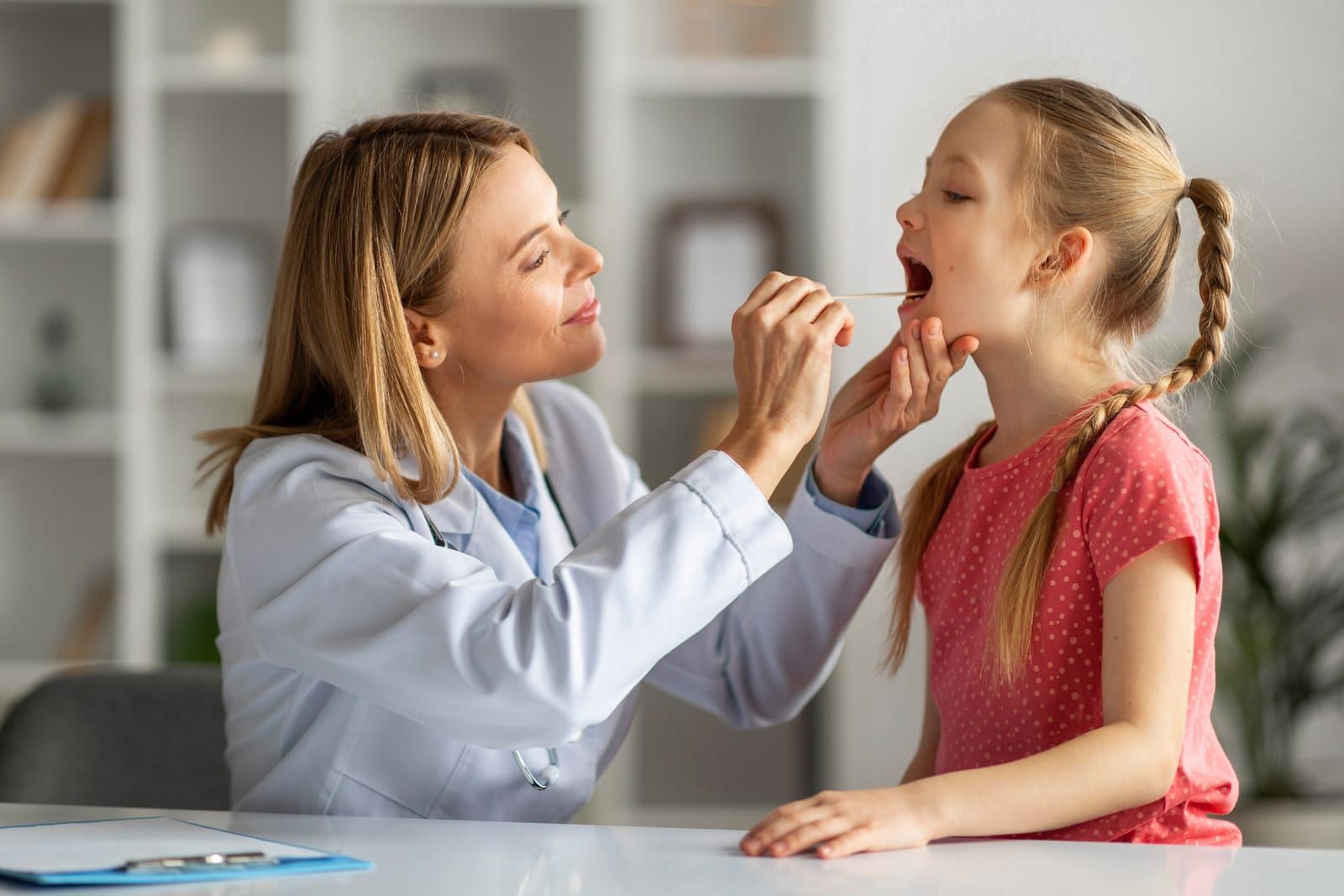 female-doctor-pediatrician-checking-throat-of-little-girl-patient