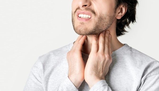 Man showing discomfort, highlighting the pain related to sleep apnea and tonsil removal